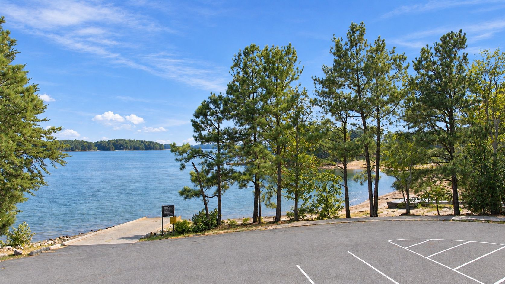 Lake Lanier boat ramp and parking area near Lake Hollow by Davidson Homes in Gainesville, Georgia, surrounded by pine trees
