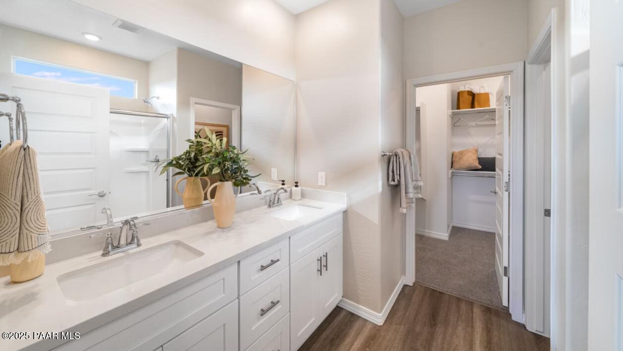 Modern master bathroom featuring double vanity, quartz counters, and walk-in closet in Davidson Homes The Newport C, Prescott, Arizona