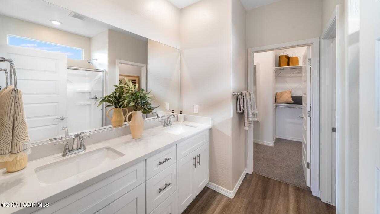Modern master bathroom featuring double vanity, quartz counters, and walk-in closet in Davidson Homes The Newport C, Prescott, Arizona