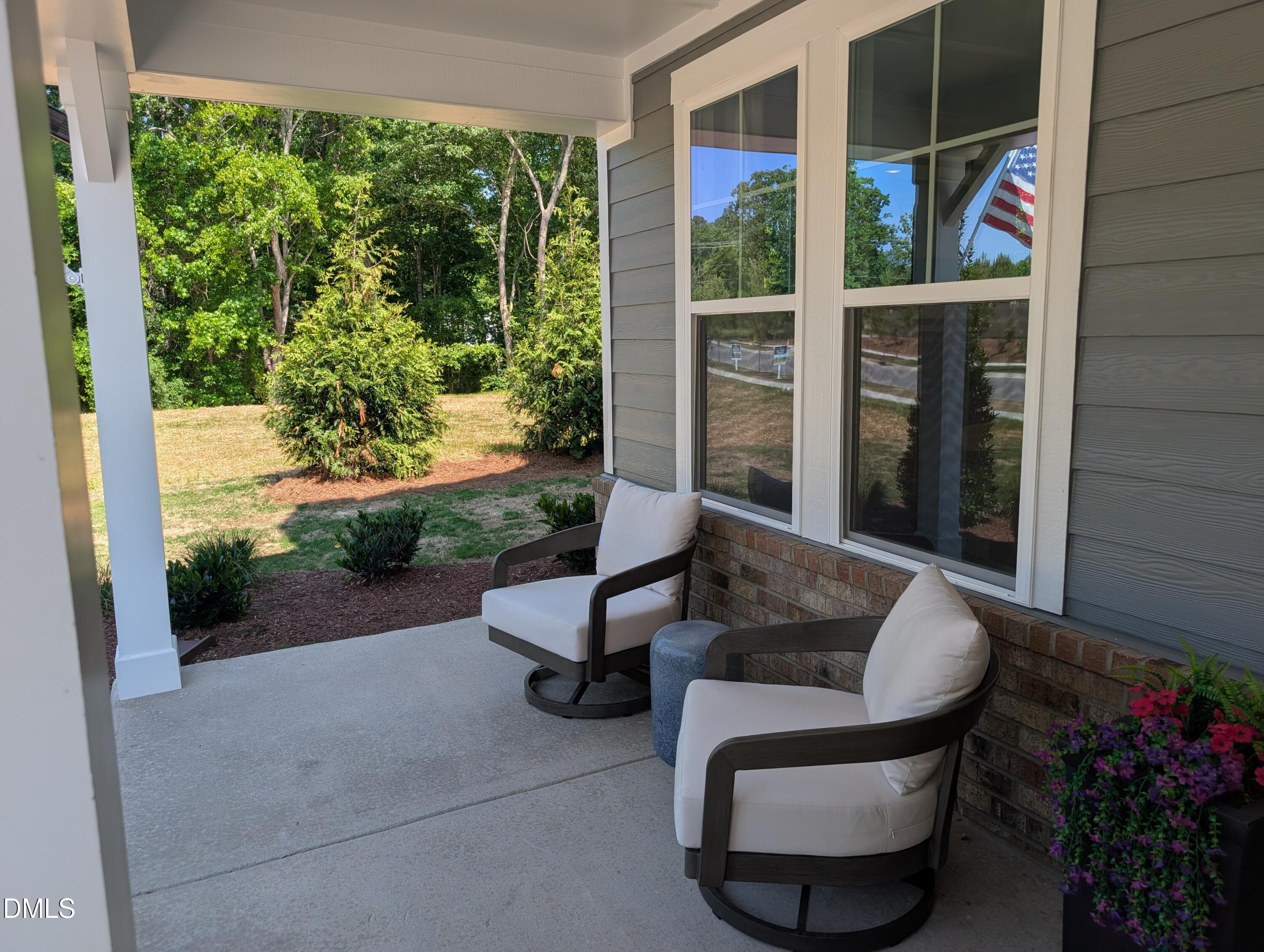 Covered front porch with patio chairs at The Aspen B floor plan by Davidson Homes in Wendell Ridge, Wendell, North Carolina.