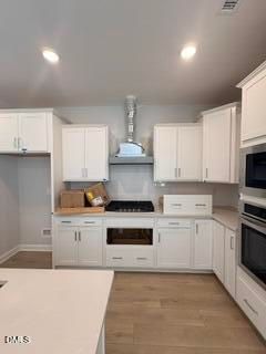 Modern white kitchen with stainless steel appliances and gas range in The Daphne D floor plan, Woodland Crossing, Zebulon.