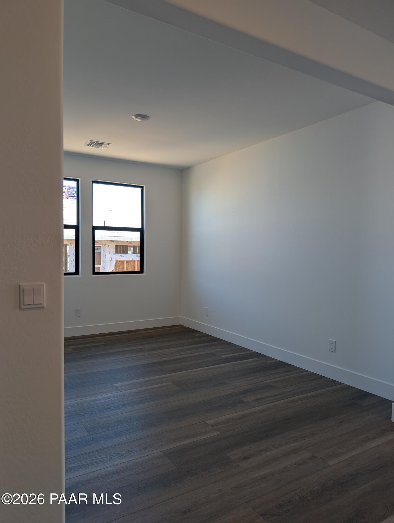 Bright secondary bedroom with large windows, white walls, and hardwood floors in The Sheridan II G, Prescott Arizona