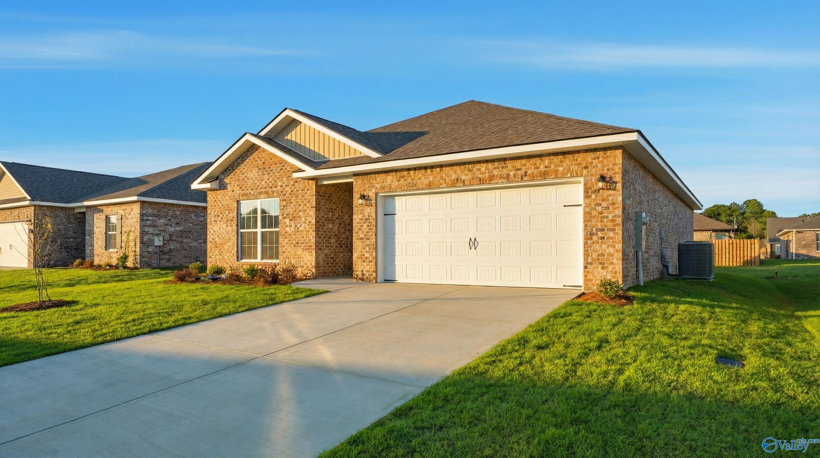 Charming brick ranch home with 2-car garage, driveway, and lush lawn in Wood Trail, Toney, Alabama - Davidson Homes The Asheville