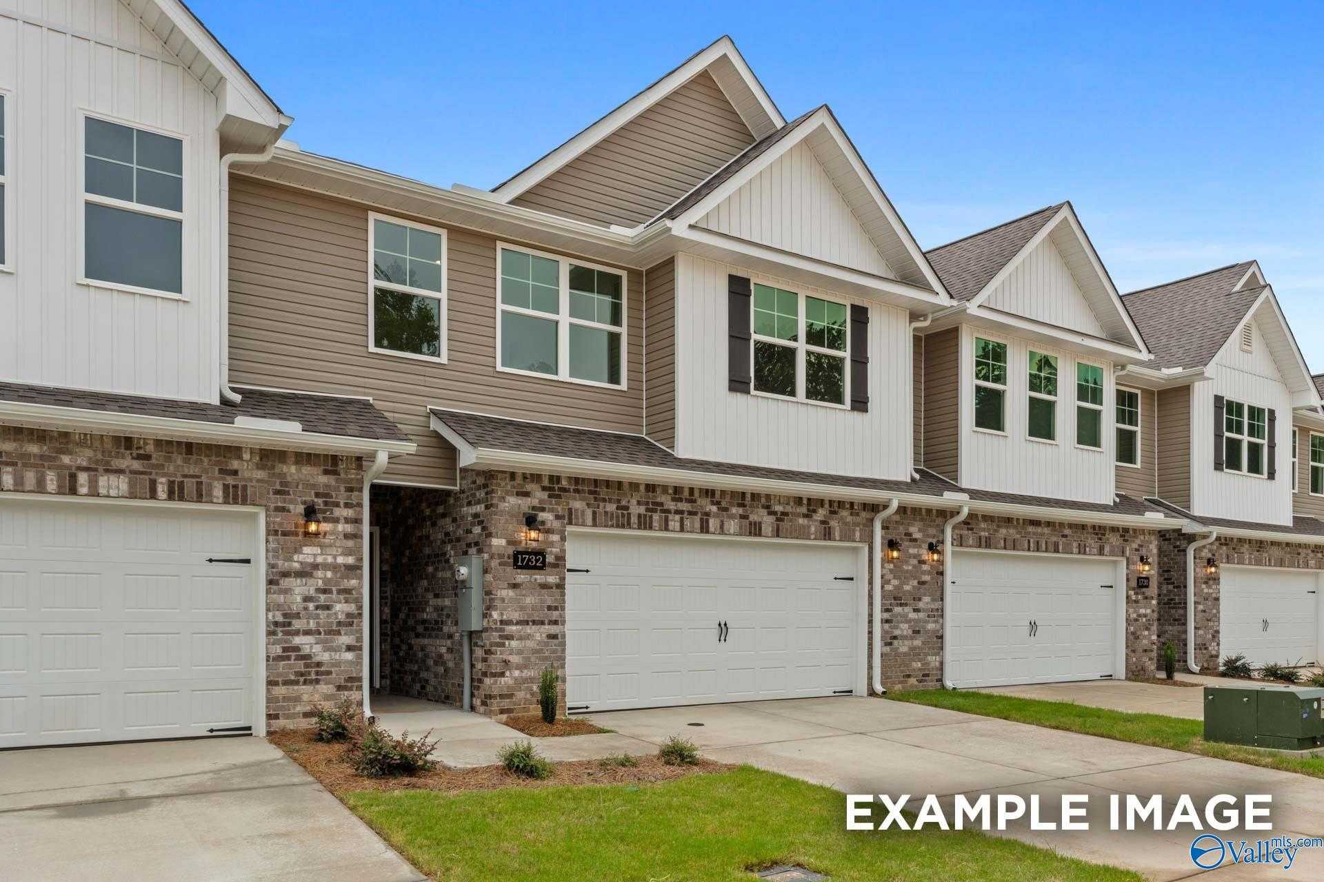 Row of modern 2-story townhomes with 2-car garages, brick accents, and beige siding in Pavilion, Huntsville, Alabama by Davidson Homes The Camden D