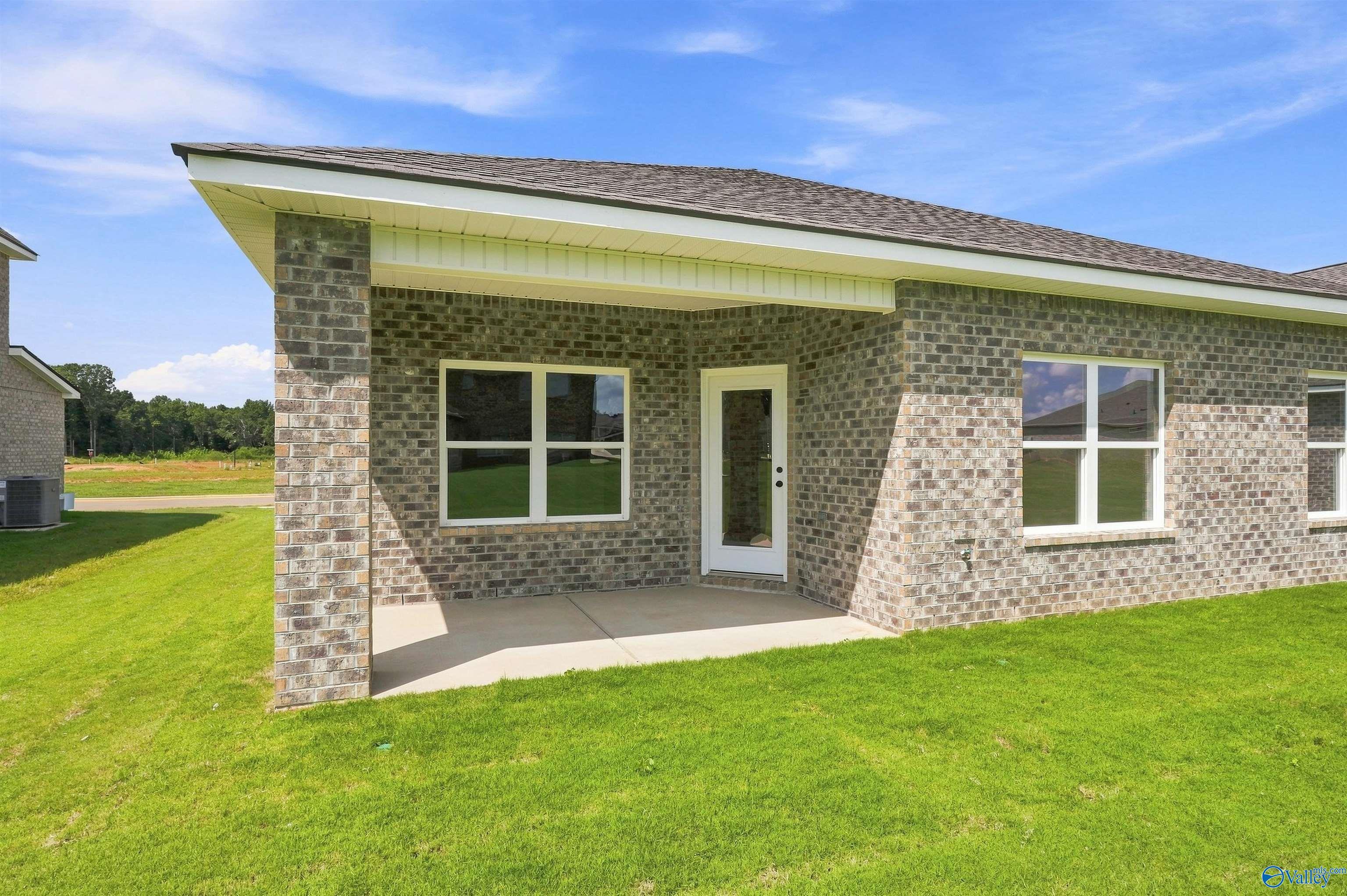 Covered brick patio with white door and windows on Davidson Homes Franklin C plan in Wood Trail, Toney, Alabama