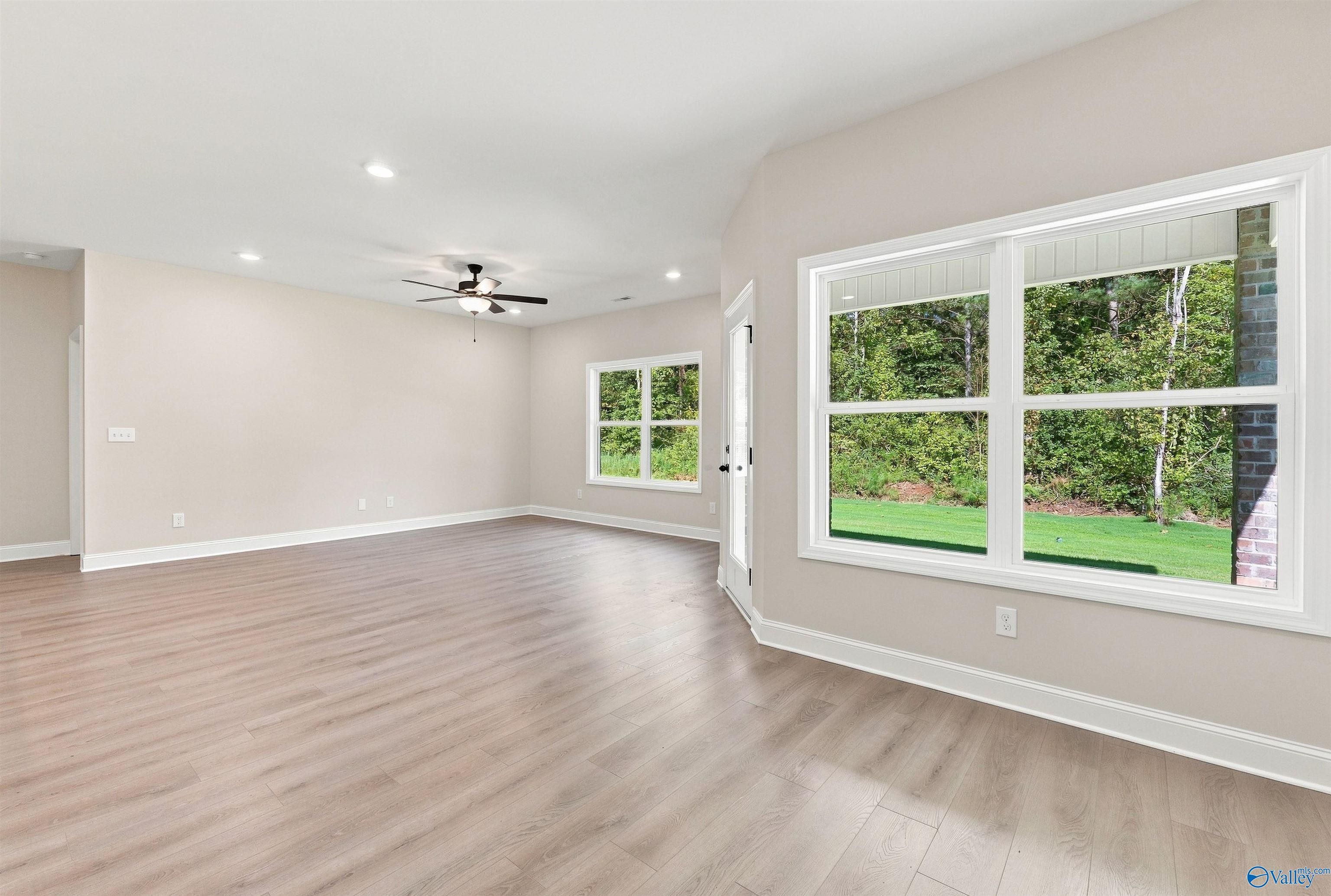 Spacious, light-filled living room with wood-look flooring in The Daphne floor plan at Spragins Cove, Huntsville, Alabama.