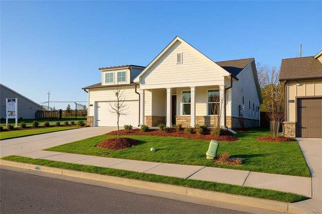 Charming white single-story home with 2-car garage, covered porch, and landscaped yard in Kelly Preserve, Loganville, Georgia - The Edison A by Davidson Homes