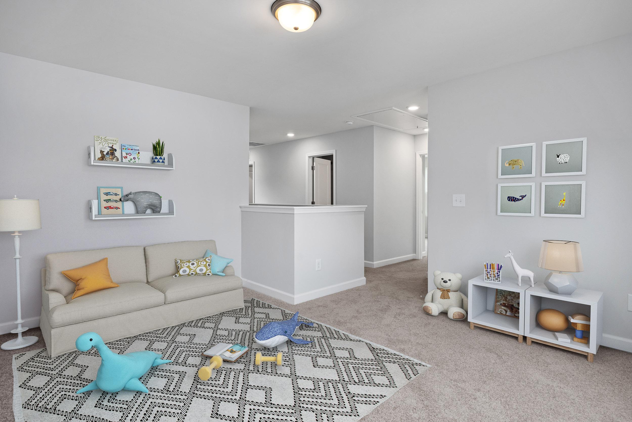 Cozy nursery in Gregory Village Townhomes, Lillington NC with gray walls, stuffed toys, bookshelves, and plush sofa on patterned rug