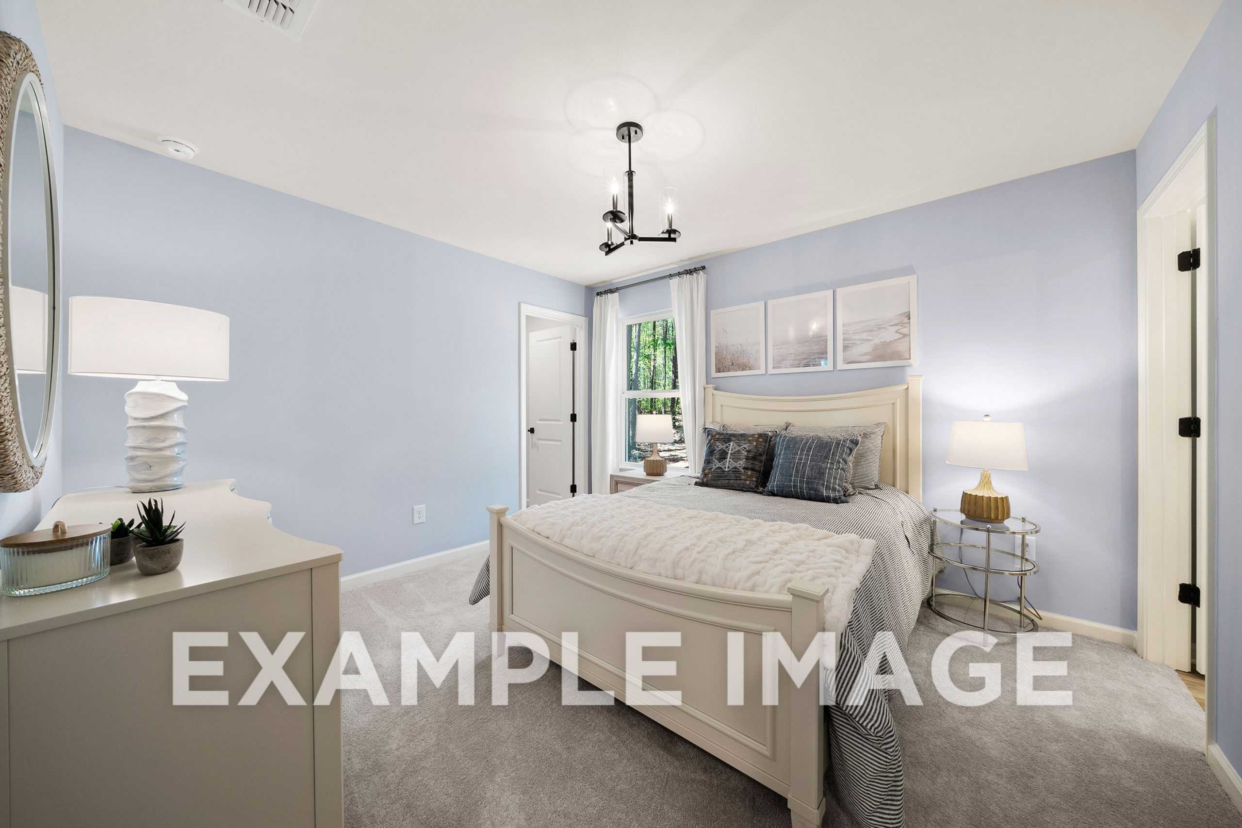 Spacious master suite in The Hickory A, light blue walls, white upholstered king bed, chandelier, large windows, modern decor