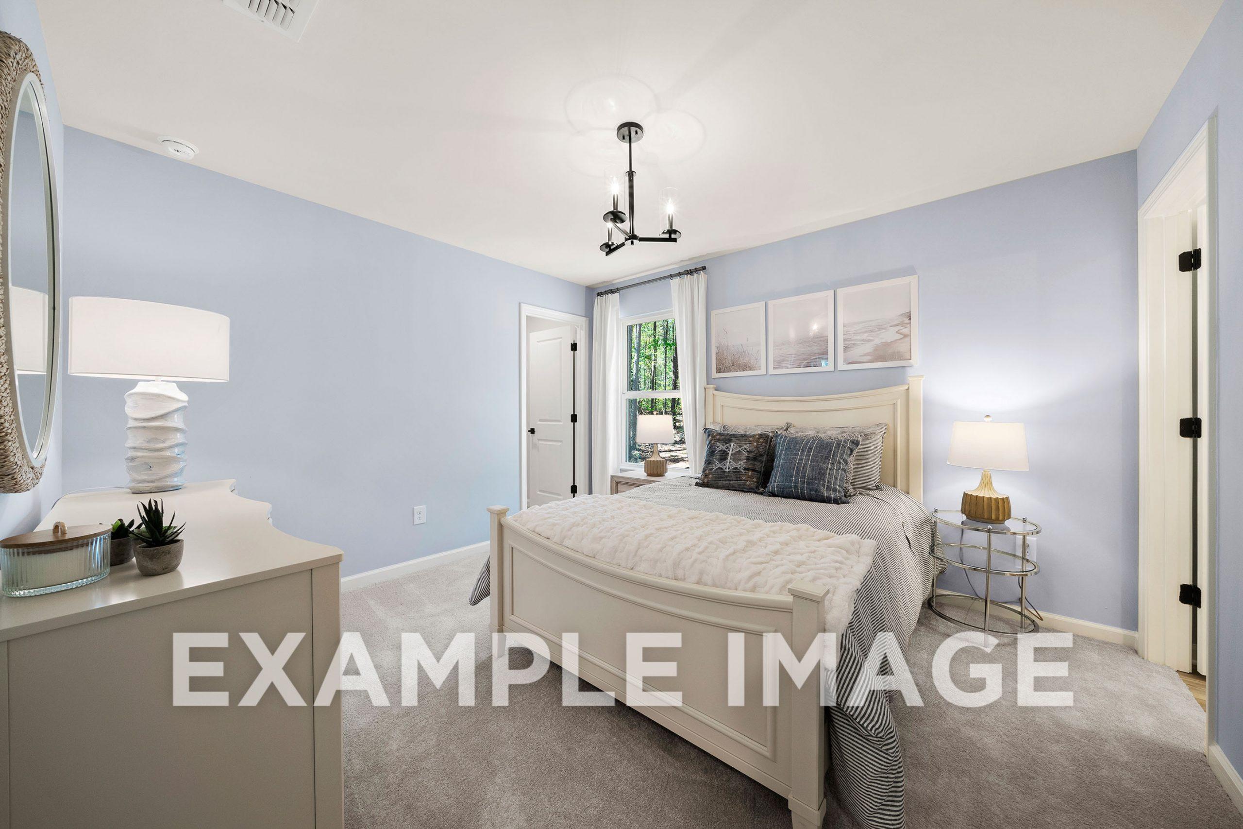 Spacious master bedroom in The Hickory B with blue walls, king bed, chandelier, and window views