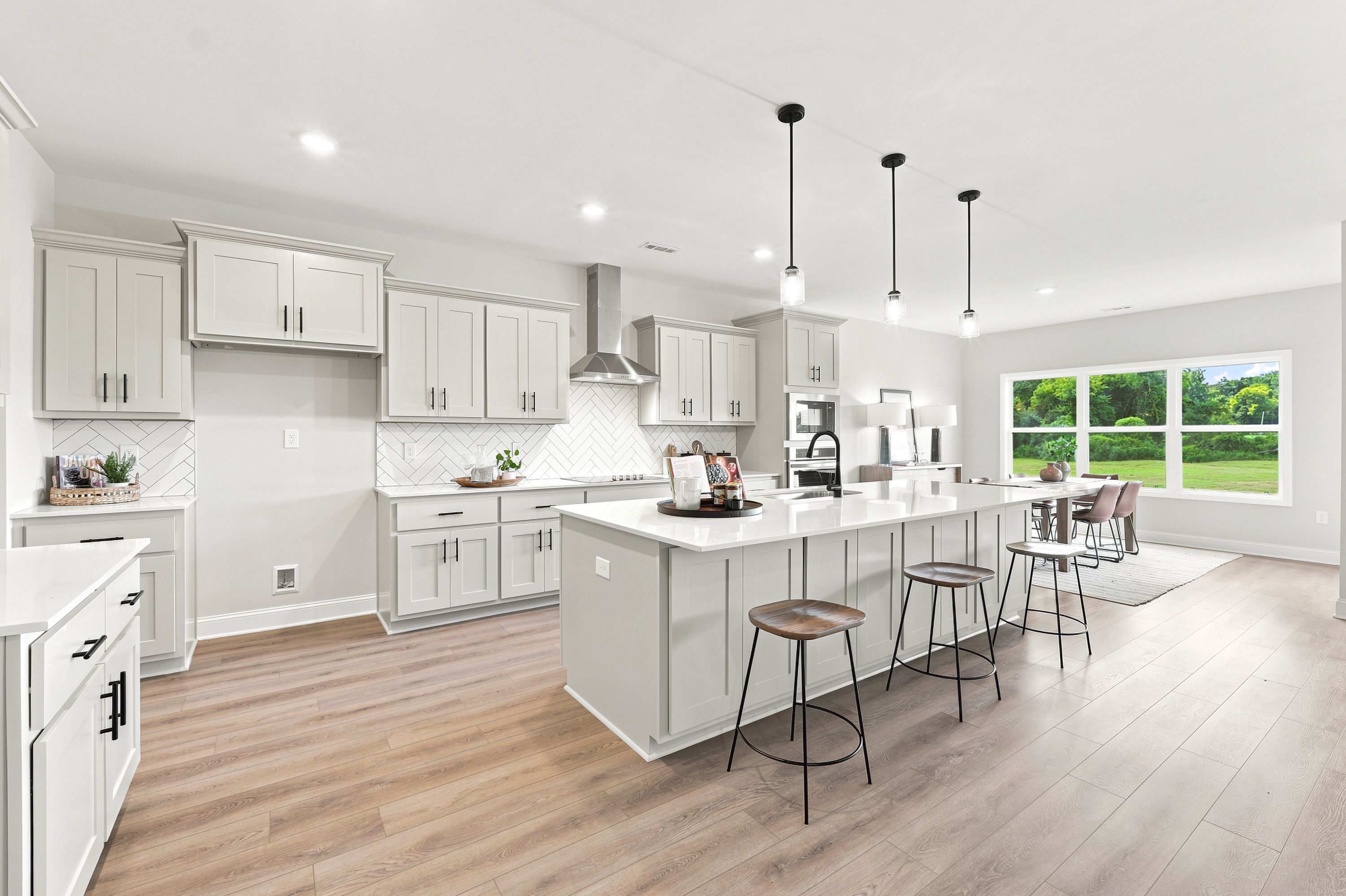 Modern kitchen with white cabinets and large island at Riverton Preserve in Huntsville, AL, built by Davidson Homes.