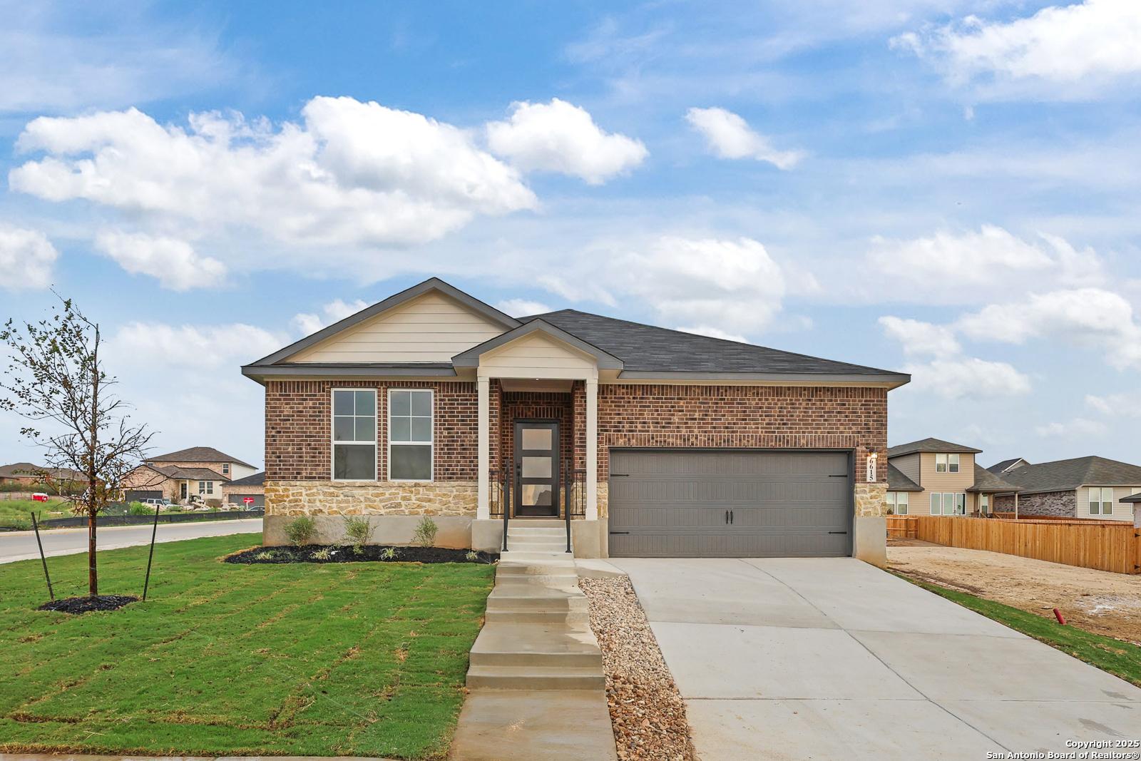 Modern 1-story brick home with stone accents, 2-car garage, and landscaped yard in Comanche Ridge, San Antonio, Texas - Davidson Homes The Daphne K