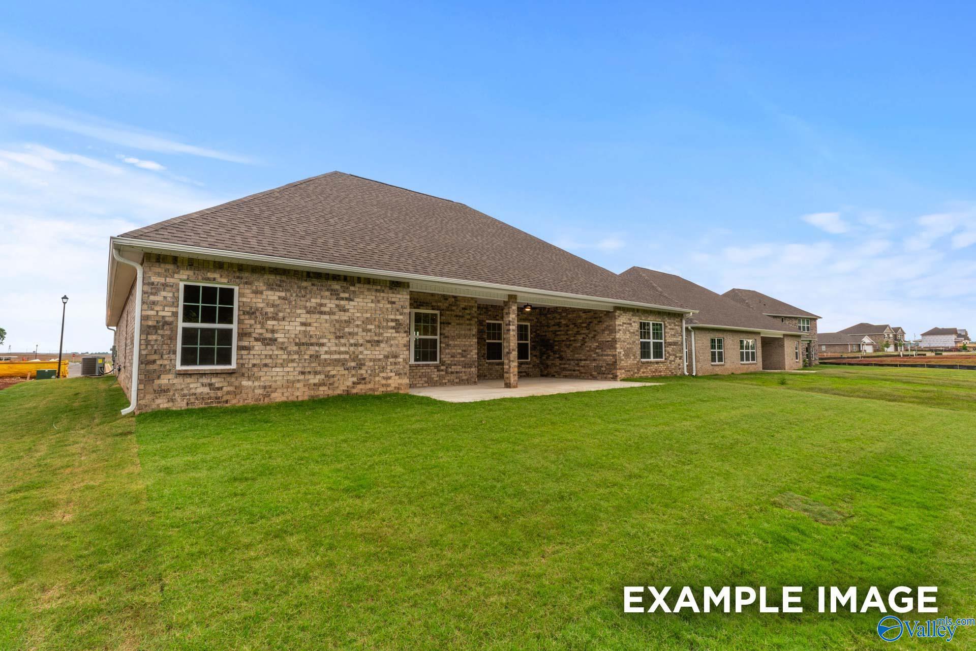 Brick ranch-style home with shingle roof, covered patio, and attached garage on green lawn in Briercreek, Meridianville, Alabama