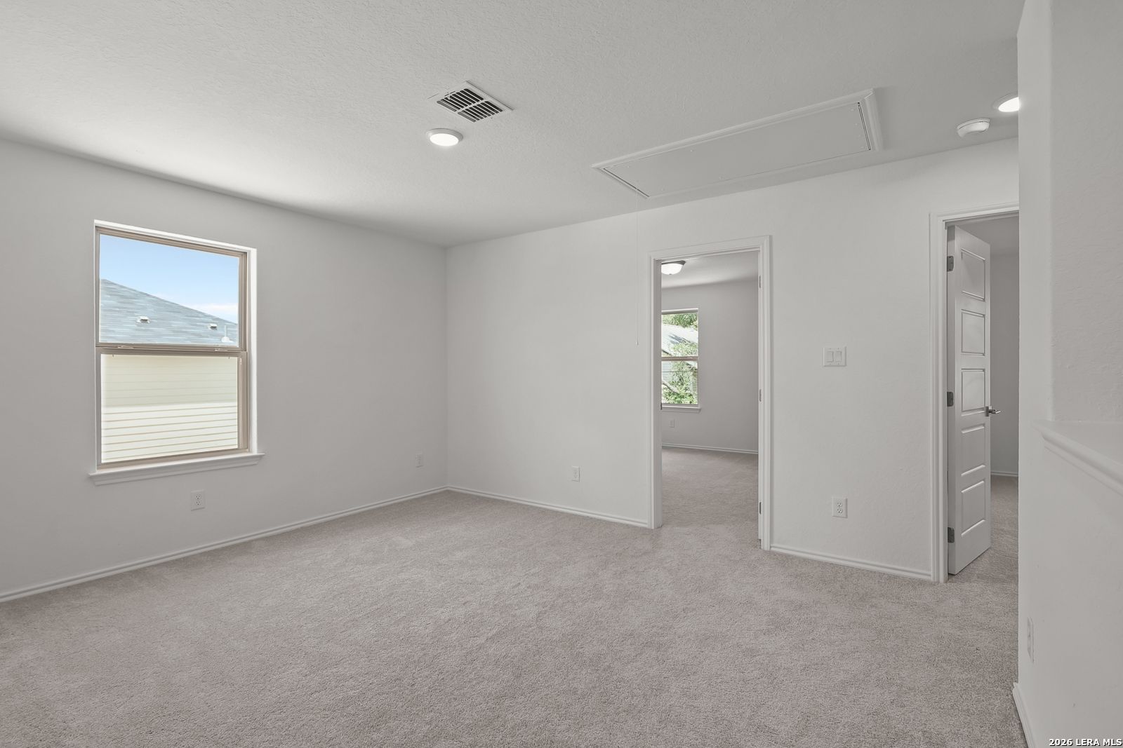 Bright, carpeted bedroom with white walls in The Gillian C floor plan by Davidson Homes in Meadows at Oak Creek.