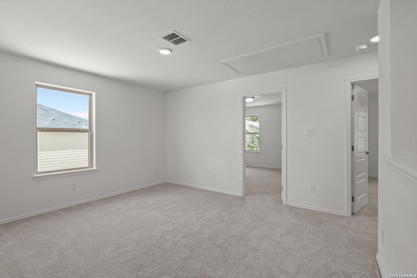 Bright, carpeted bedroom with white walls in The Gillian C floor plan by Davidson Homes in Meadows at Oak Creek.