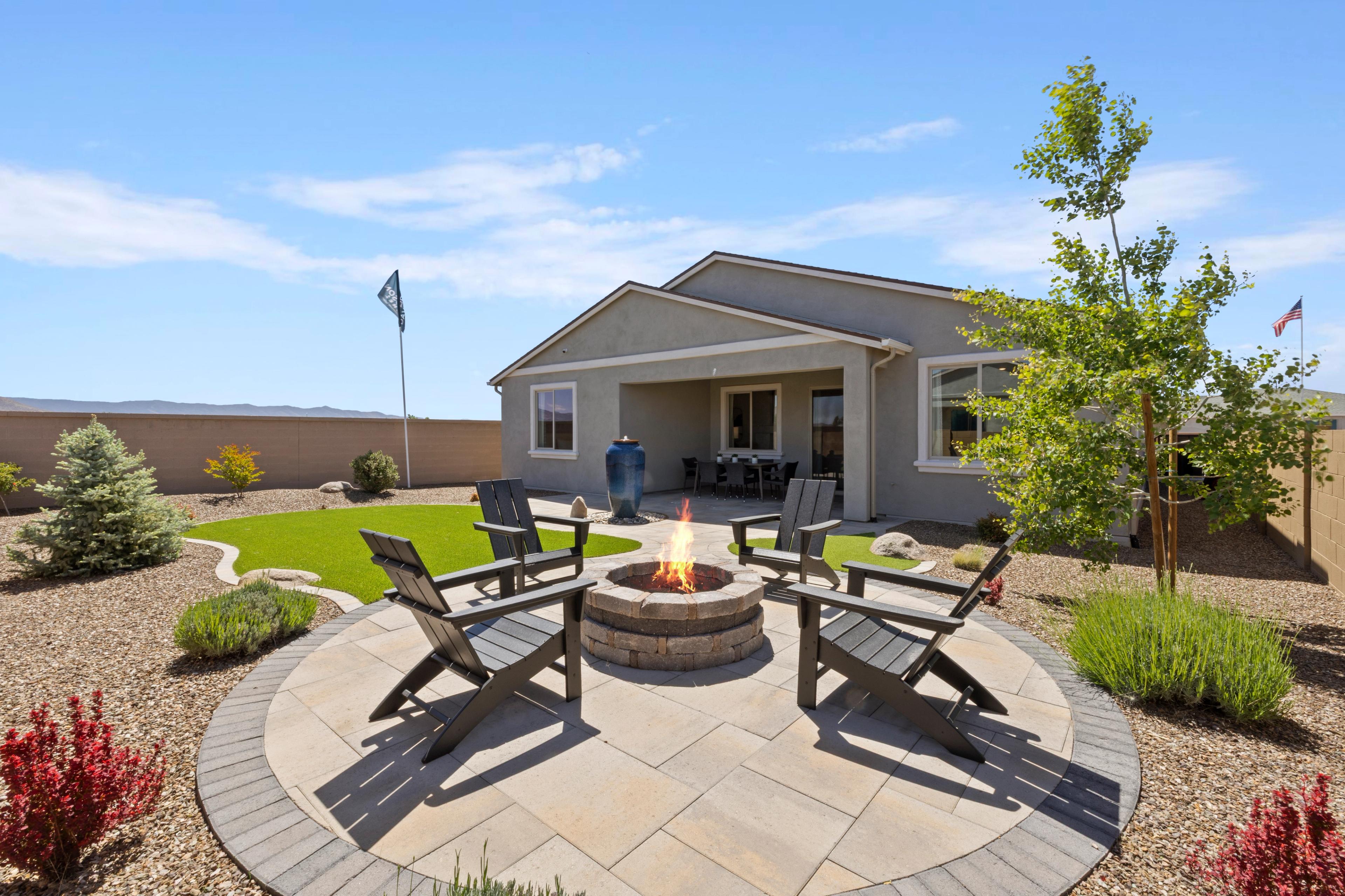 Cozy stone fire pit with Adirondack chairs on paver patio at North Ridge in Pronghorn Ranch, Prescott Valley AZ desert landscaping