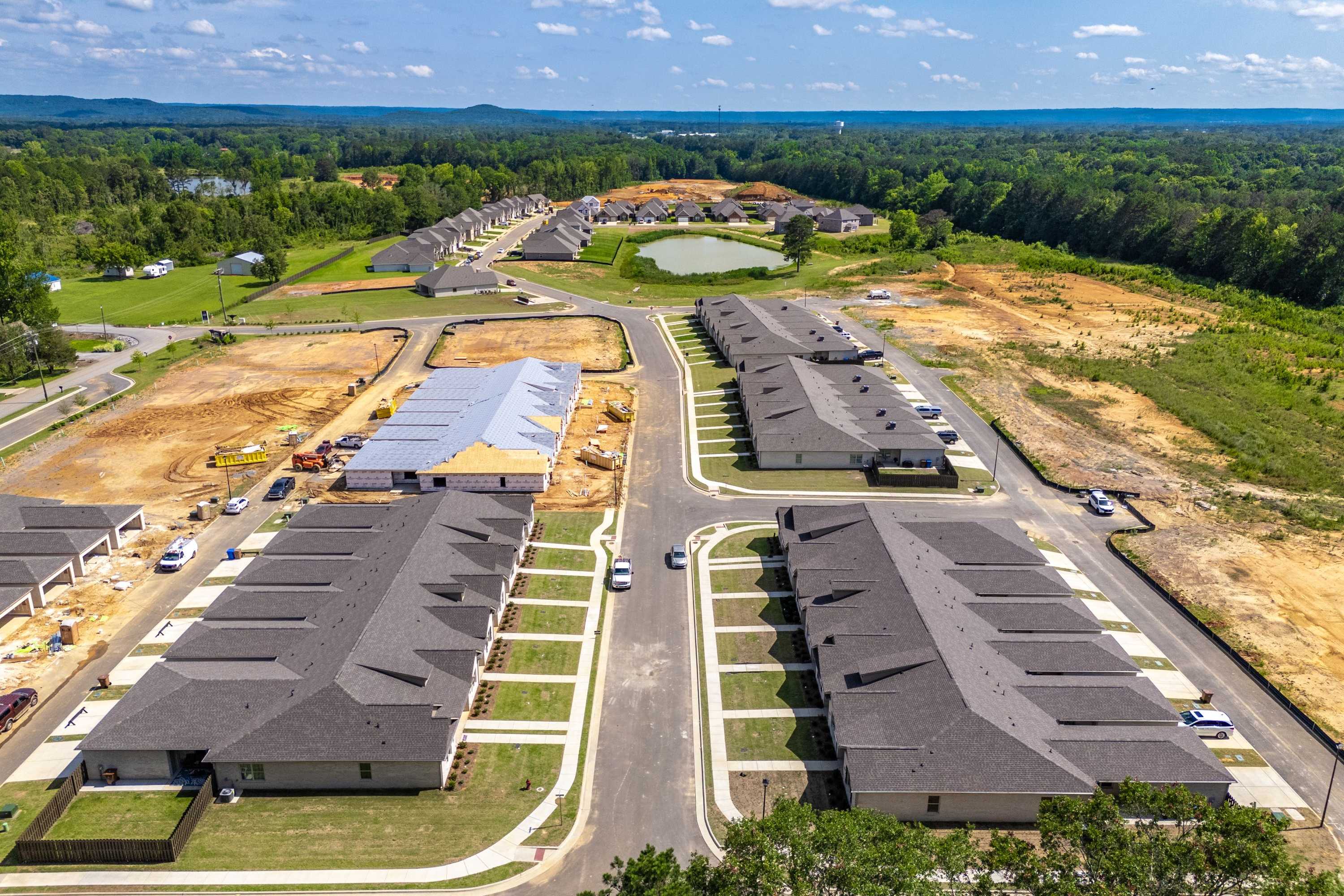 Aerial view of new townhomes under construction at The Retreat at Cain Park in Hartselle Alabama with wooded surroundings