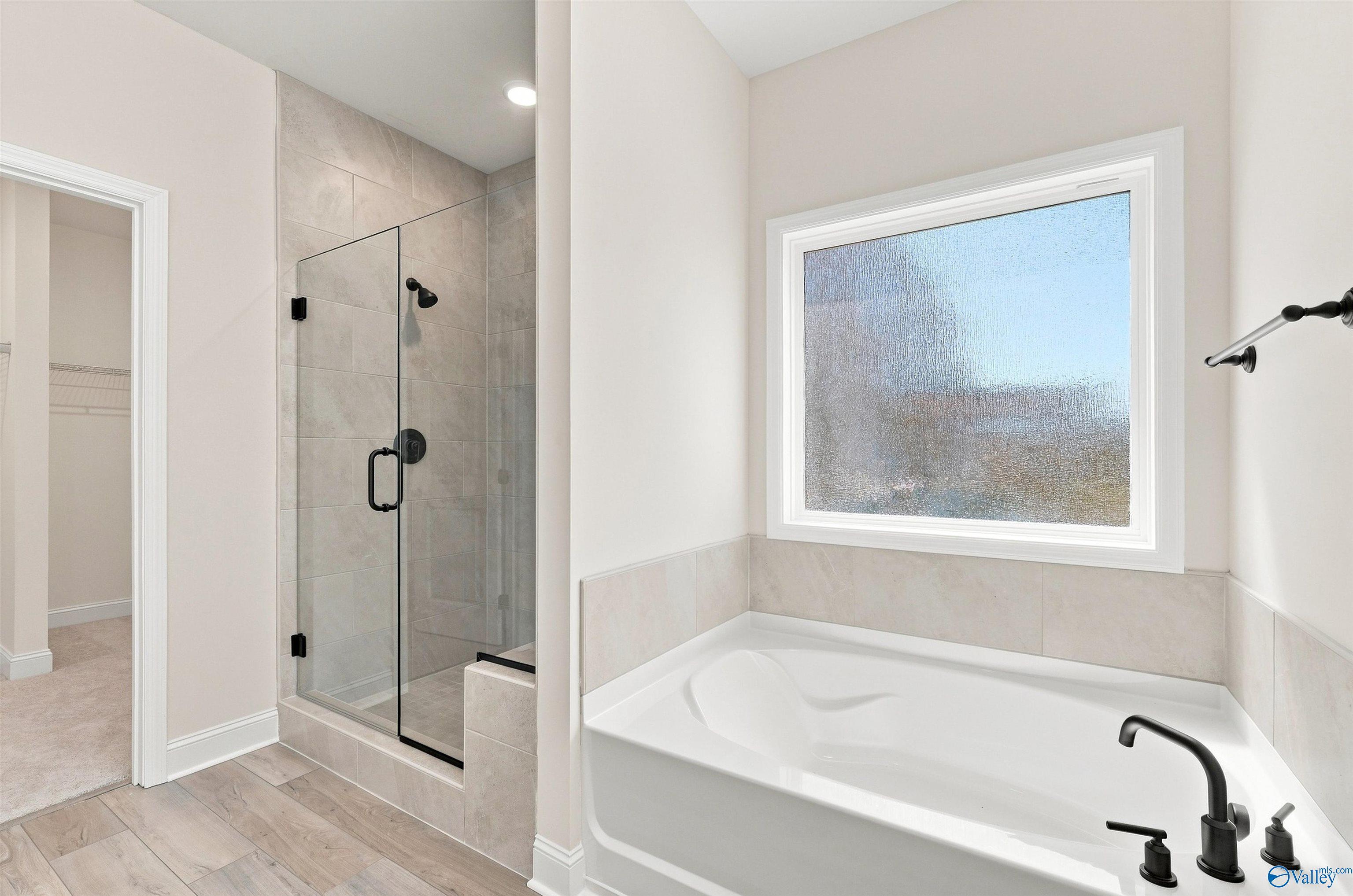 Master bath with garden tub, glass walk-in shower, and matte black fixtures in Davidson Homes The Everett B, Toney Alabama