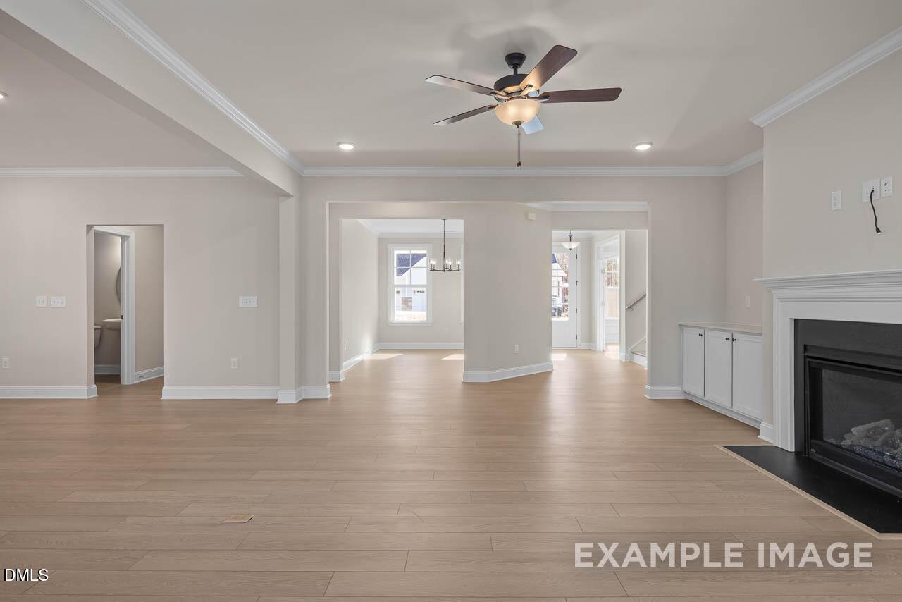 Spacious great room with hardwood floors, ceiling fan, gas fireplace, and open layout in Davidson Homes The Crawford D, Angier, NC