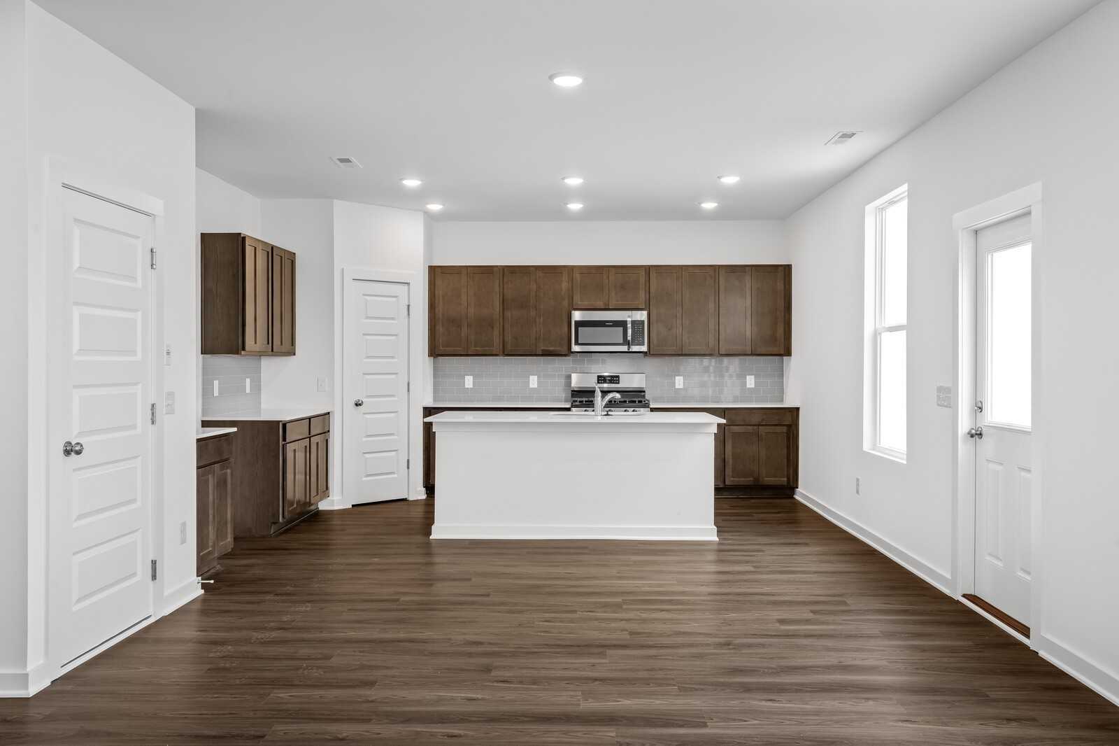 Modern kitchen featuring shaker cabinets, white quartz island, stainless appliances in Davidson Homes The Logan C, White House, TN