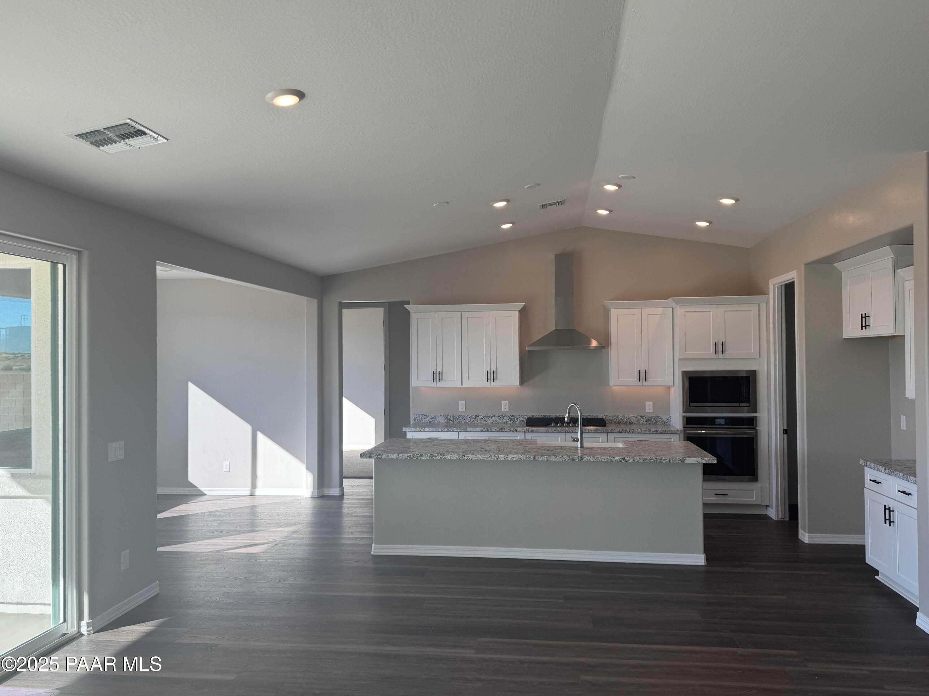 Modern kitchen with white cabinets, granite island, stainless appliances in Davidson Homes The Monarch E, Prescott, AZ