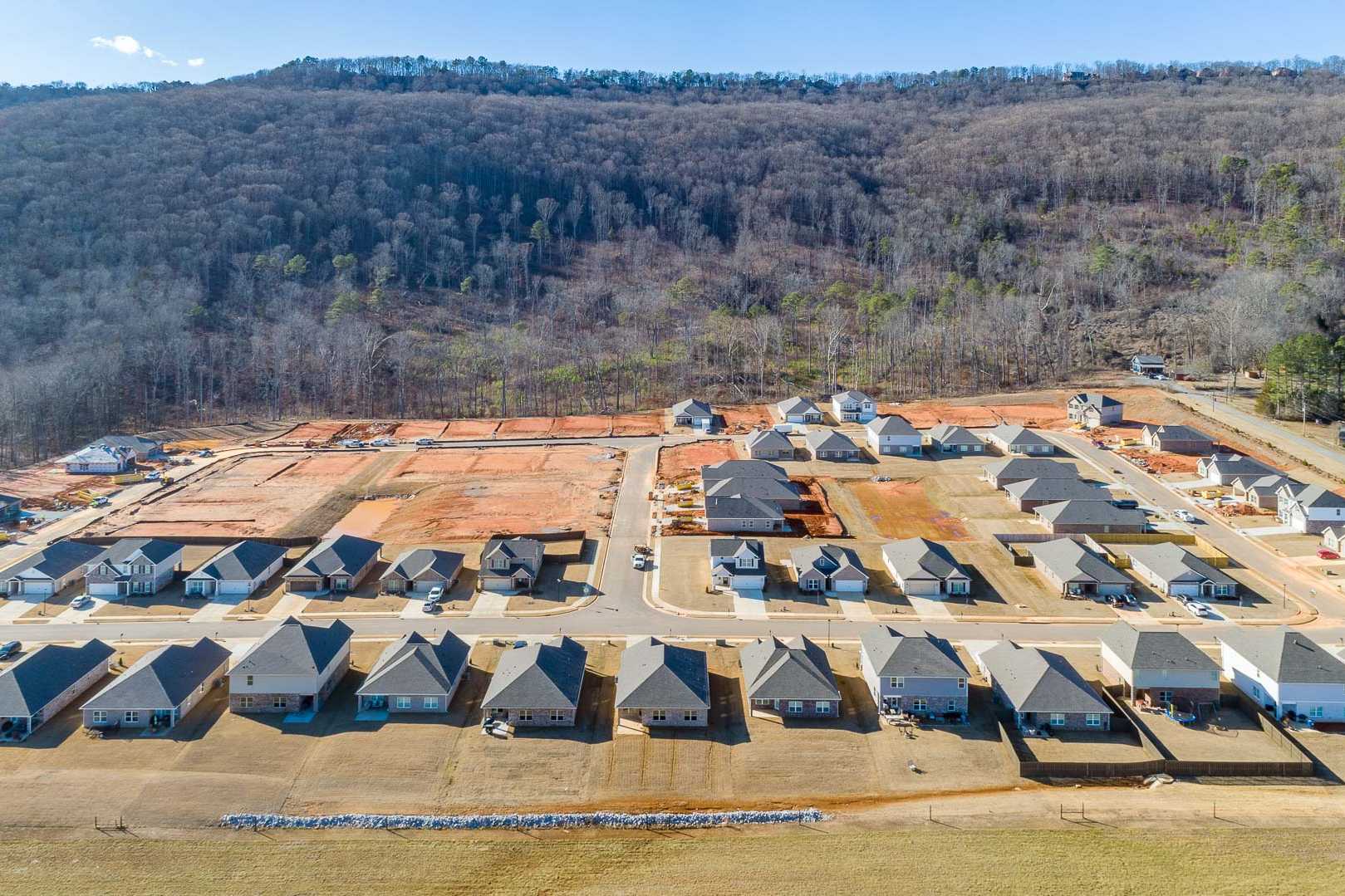 Aerial view of Monteagle Cove in Owens Cross Roads, Alabama featuring new Davidson Homes amid wooded hills and construction sites