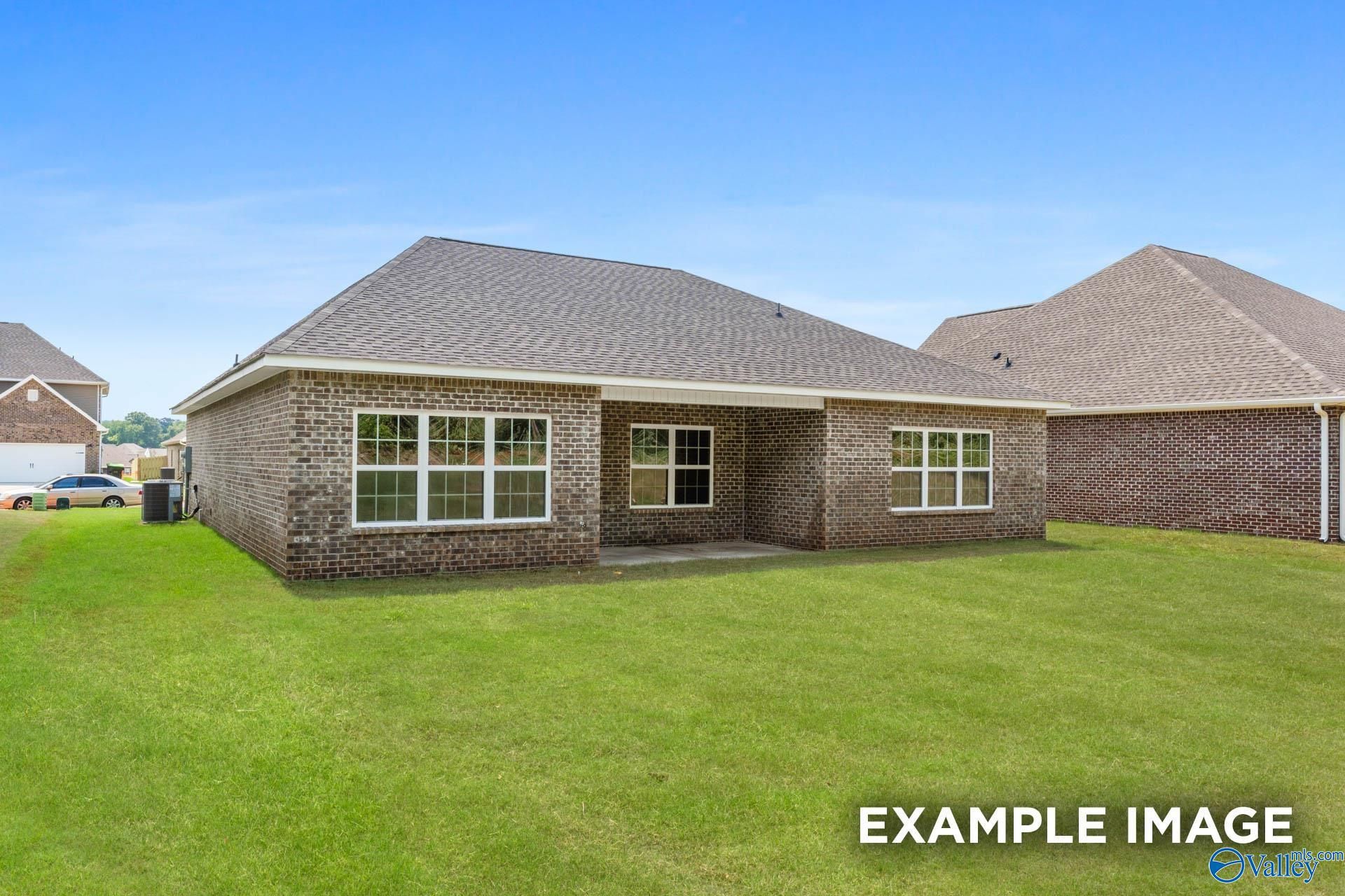 Brick single-story home with shingled roof, large windows, and green lawn in Pikes Ridge, Meridianville, Alabama - Davidson Homes Montgomery