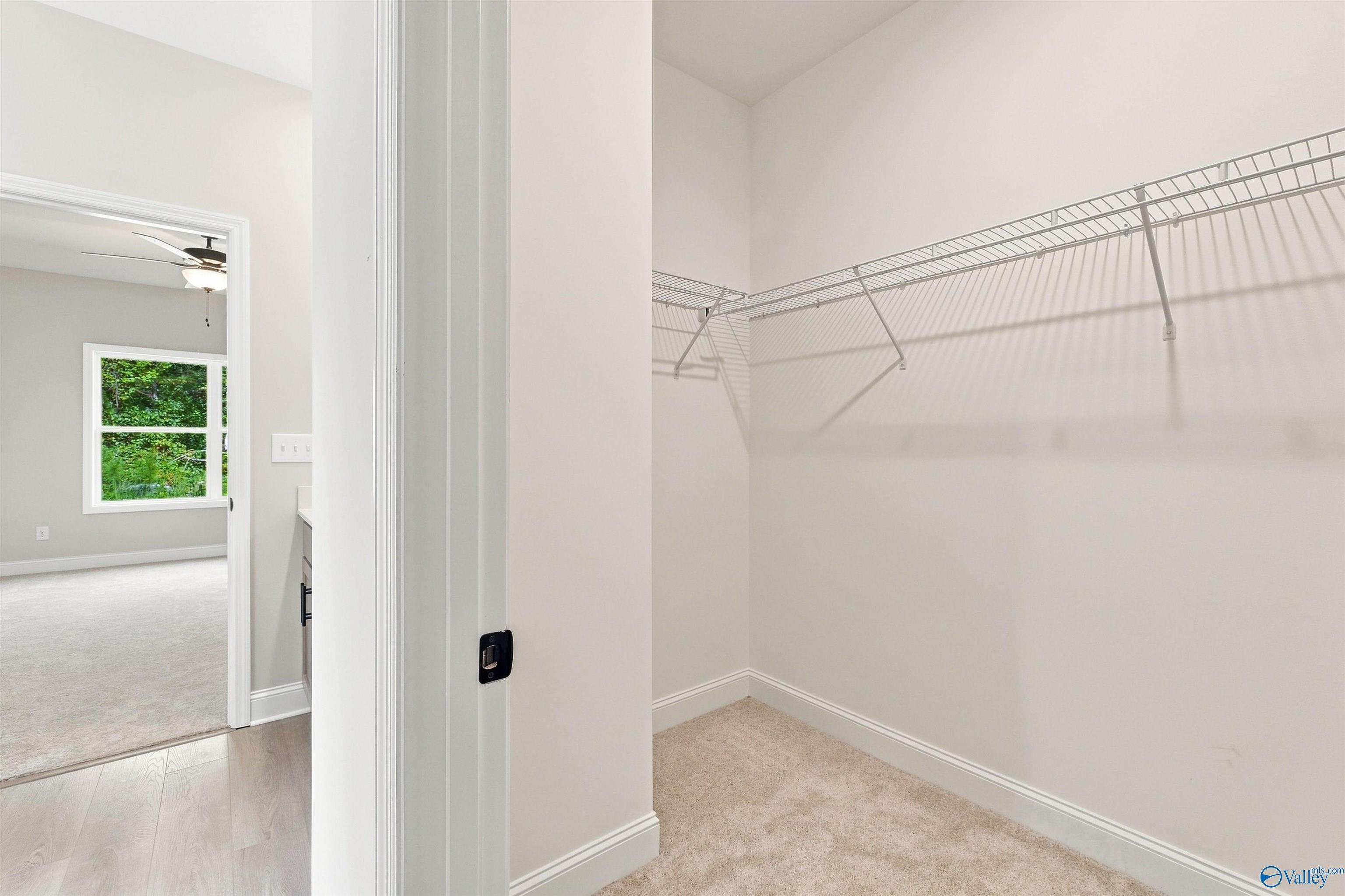 Walk-in closet with white wire shelving in The Daphne floor plan by Davidson Homes in Spragins Cove, Huntsville, Alabama.
