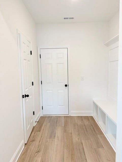 Modern mudroom with built-in bench and wood-look floors in The Hickory B floor plan at Wehunt Meadows, Hoschton, Georgia.