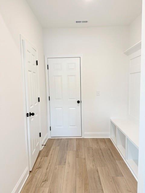 Modern mudroom with built-in bench and wood-look floors in The Hickory B floor plan at Wehunt Meadows, Hoschton, Georgia.