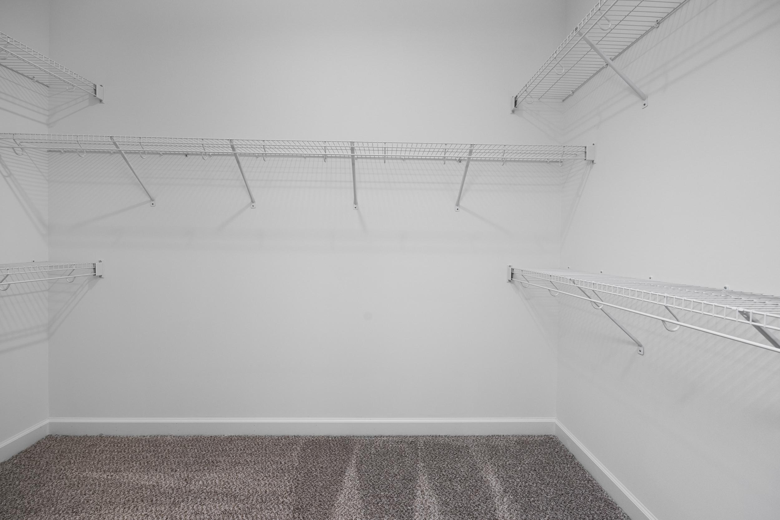 Spacious walk-in closet with wire shelving and neutral carpet in Tobacco Road home, Angier, North Carolina