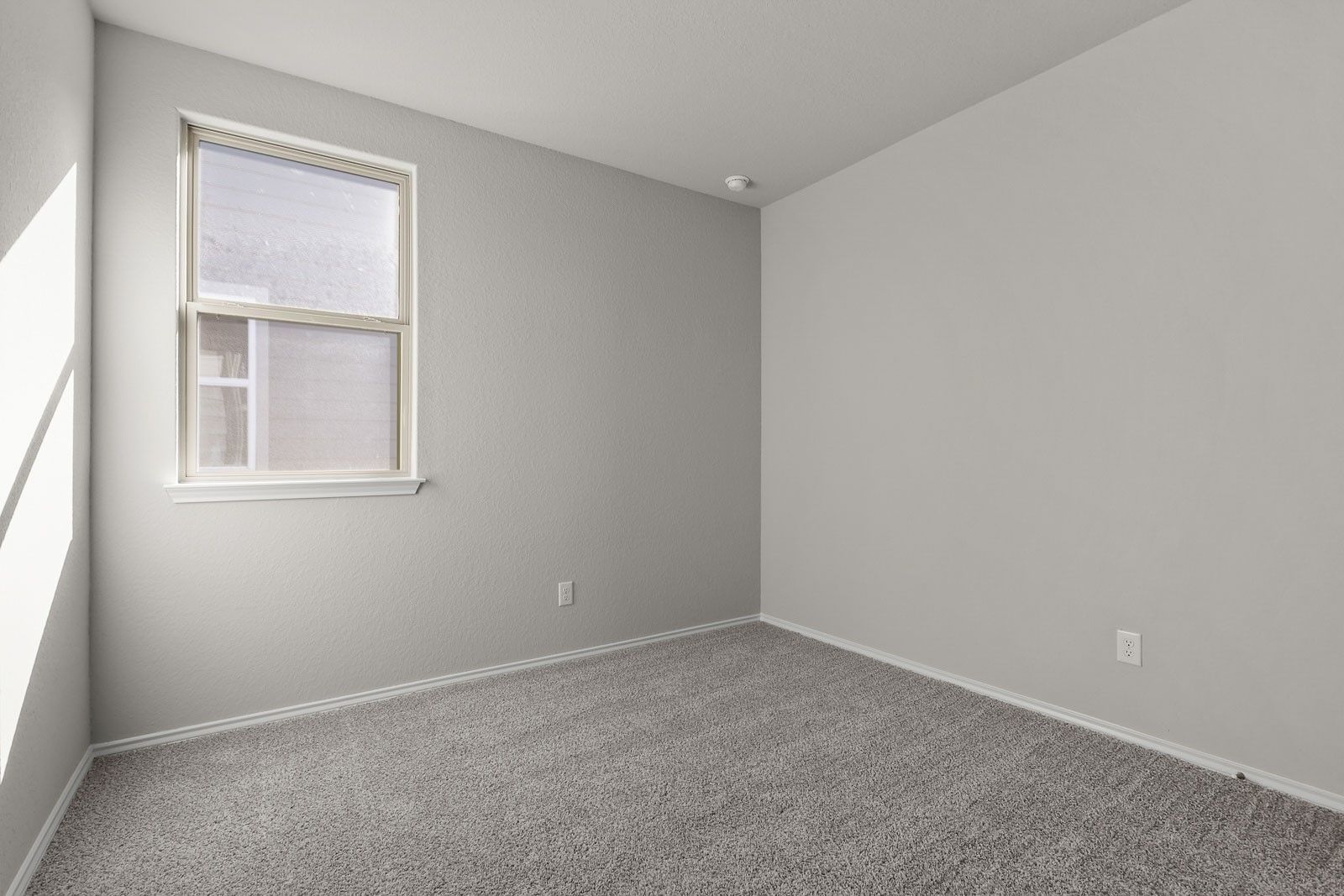 Bright, neutral-toned bedroom with carpeted flooring in The Frio G floor plan by Davidson Homes in Heartland, Texas.