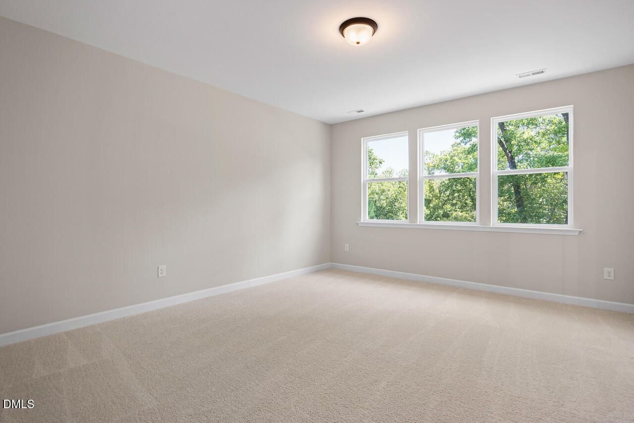 Bright, spacious bedroom with neutral carpet and natural light in The Chestnut floor plan at Montrose, Aberdeen, NC.