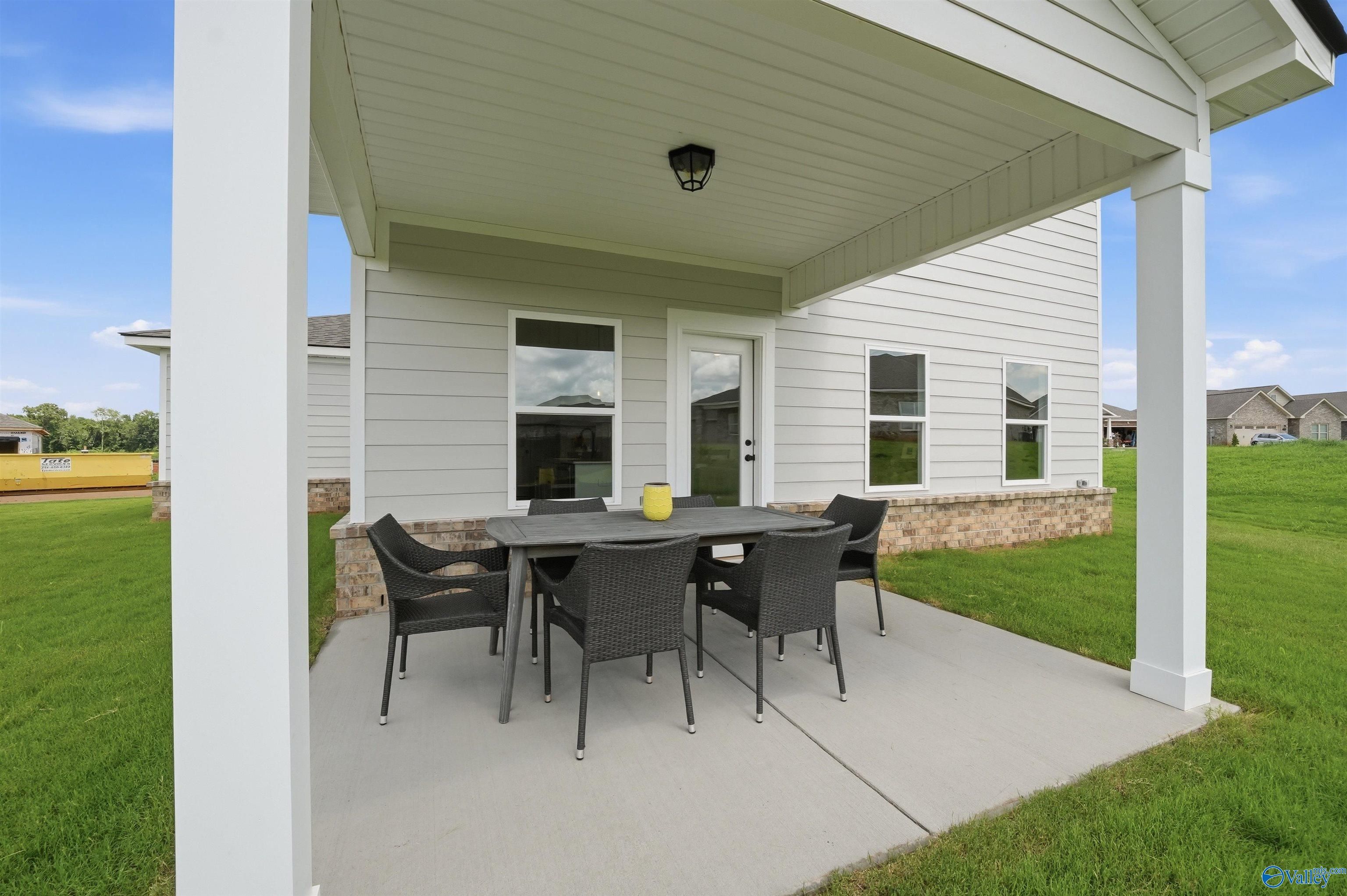 Covered back patio with outdoor dining set at The Burton B floor plan in Heritage Lakes, New Market, Alabama.