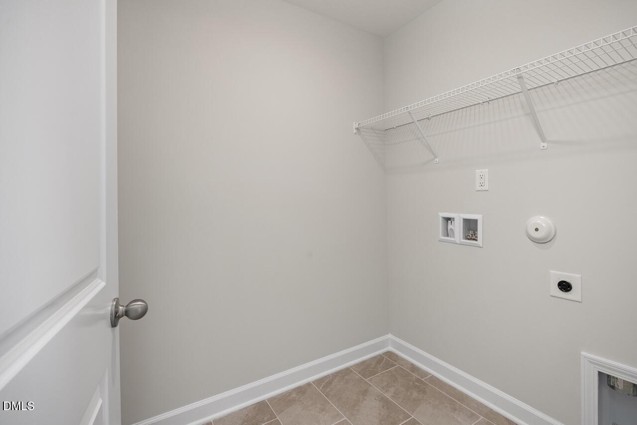 Laundry room with wire shelving and tile flooring in The Adalynn A floor plan at Gregory Village, Lillington, NC.