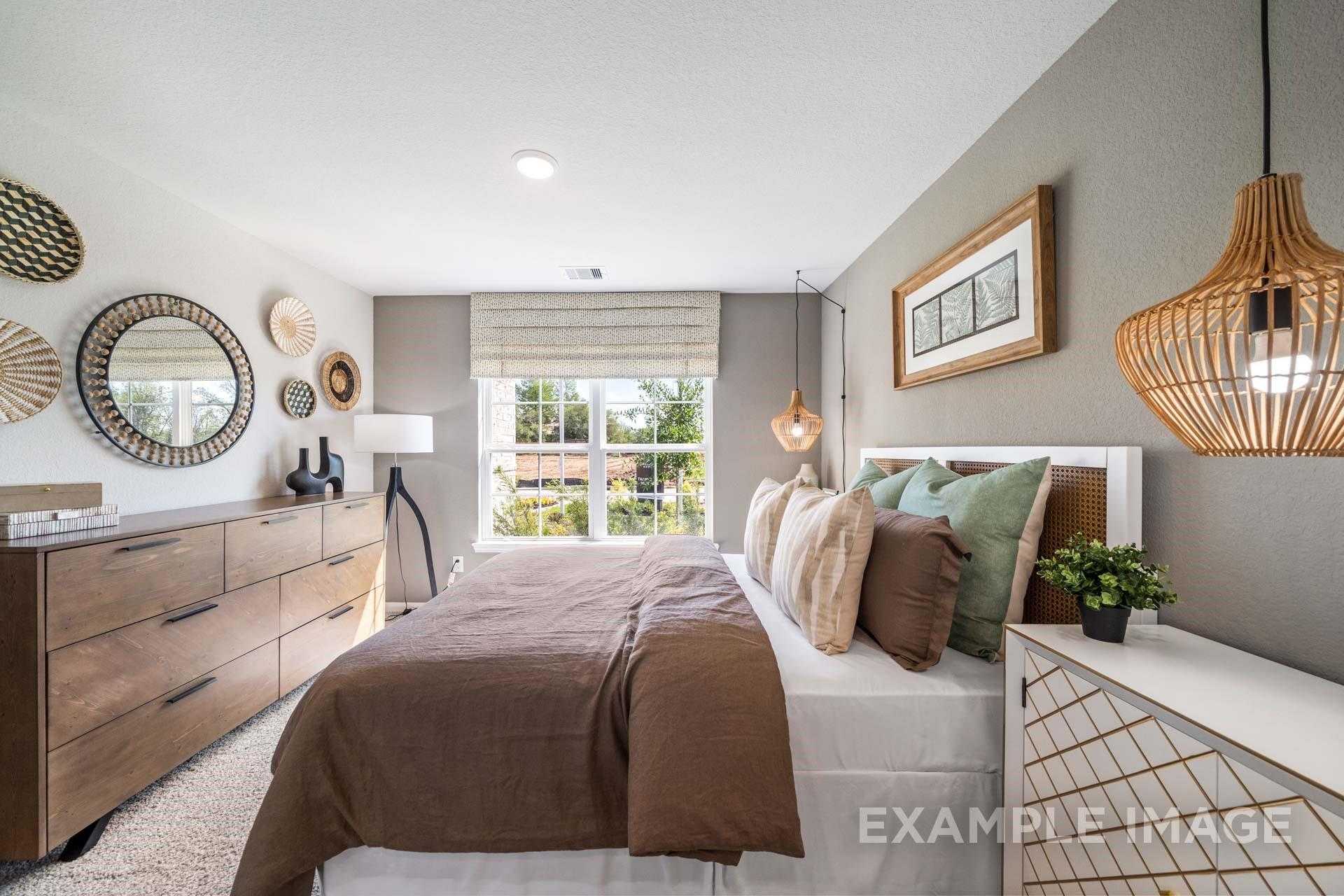 Tranquil master bedroom with king bed, rattan accents, woven decor, and window views in Davidson Homes Acadia A, Lago Mar, Texas City