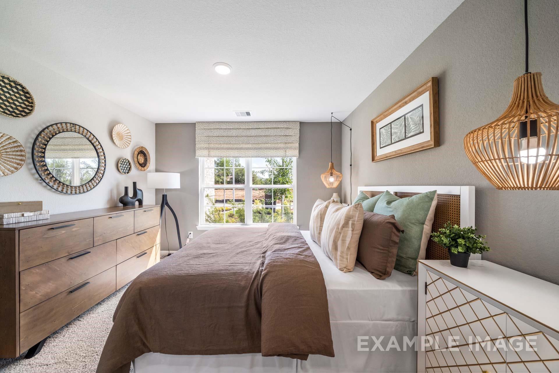 Cozy bedroom with rattan pendant light, wood dresser, and large windows in Davidson Homes The Acadia A in Lago Mar, Texas City
