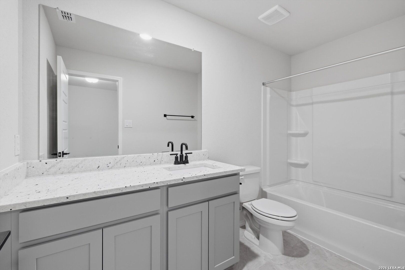 Modern bathroom with double quartz vanity, gray cabinets, tub-shower combo in Davidson Homes The Blanco C, Agave, San Antonio