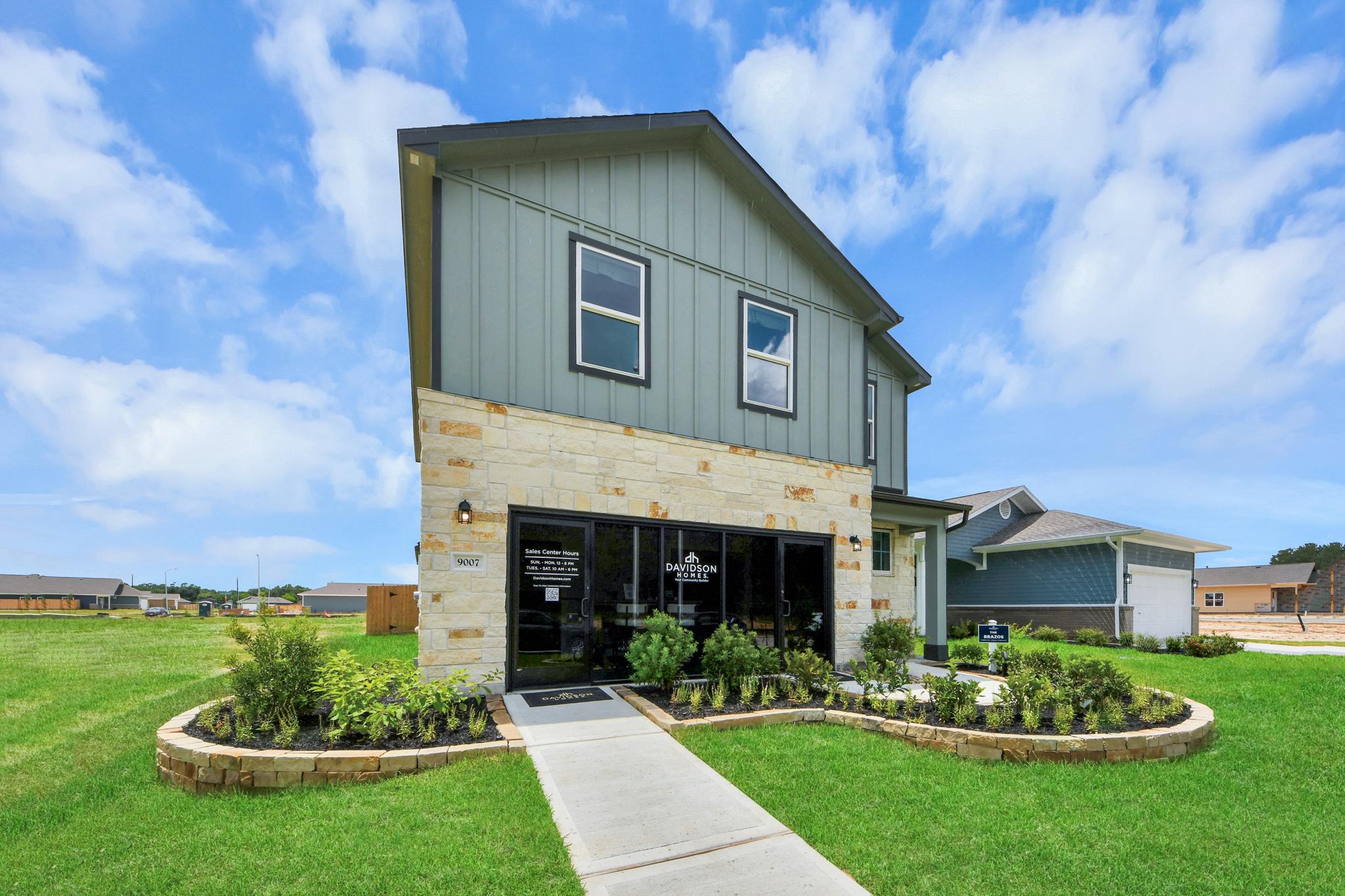 Davidson Homes sales center at Robins Landing in Houston, Texas featuring stone and vertical siding exterior.