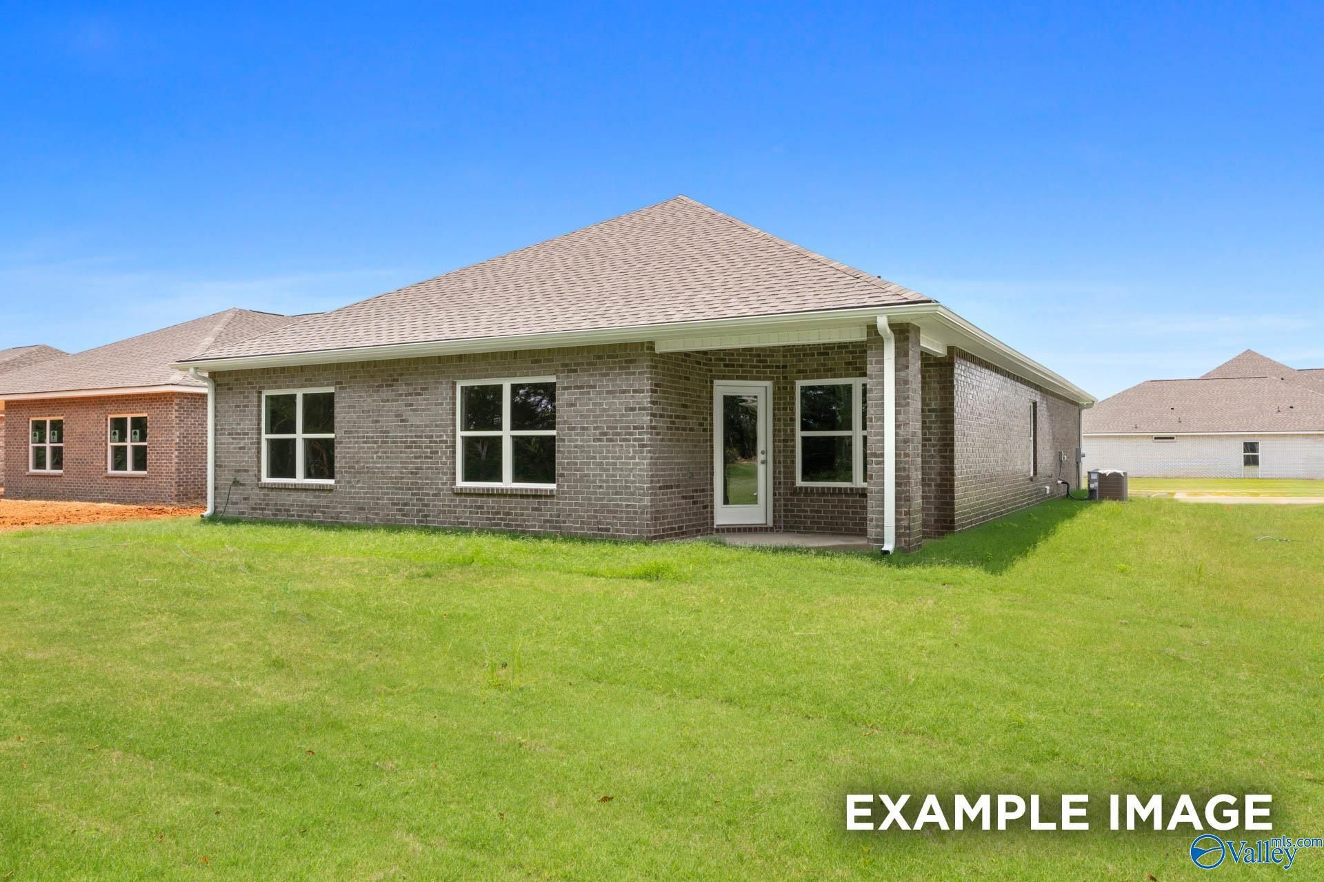 Single-story brick 4-bedroom home exterior with gabled roof and lush green lawn in Carroll Green, Harvest, Alabama - The Daphne E by Evermore Homes