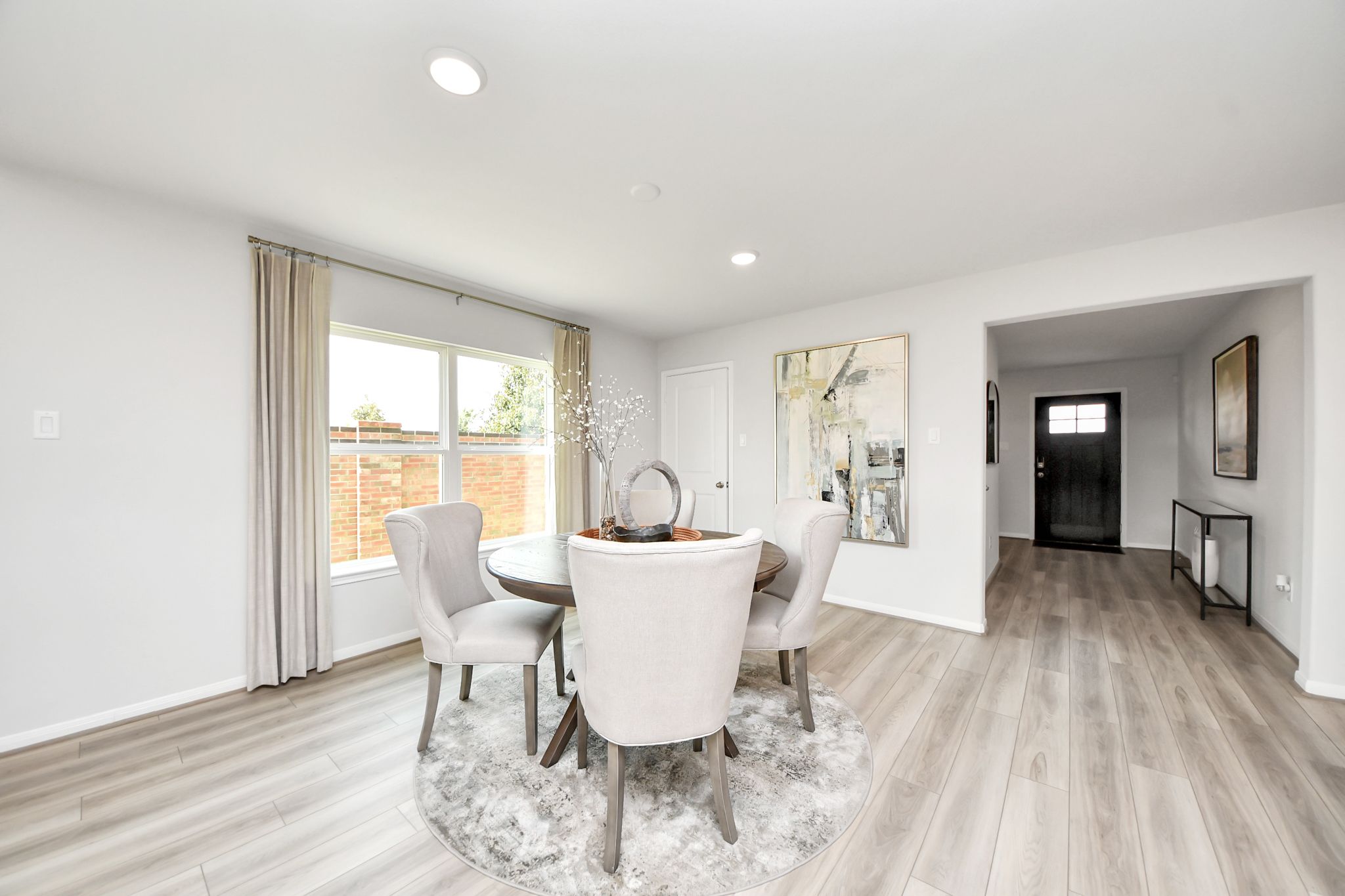 Bright dining area in a Davidson Homes floor plan at Sunterra in Katy, Texas, featuring wood-look floors and modern decor.