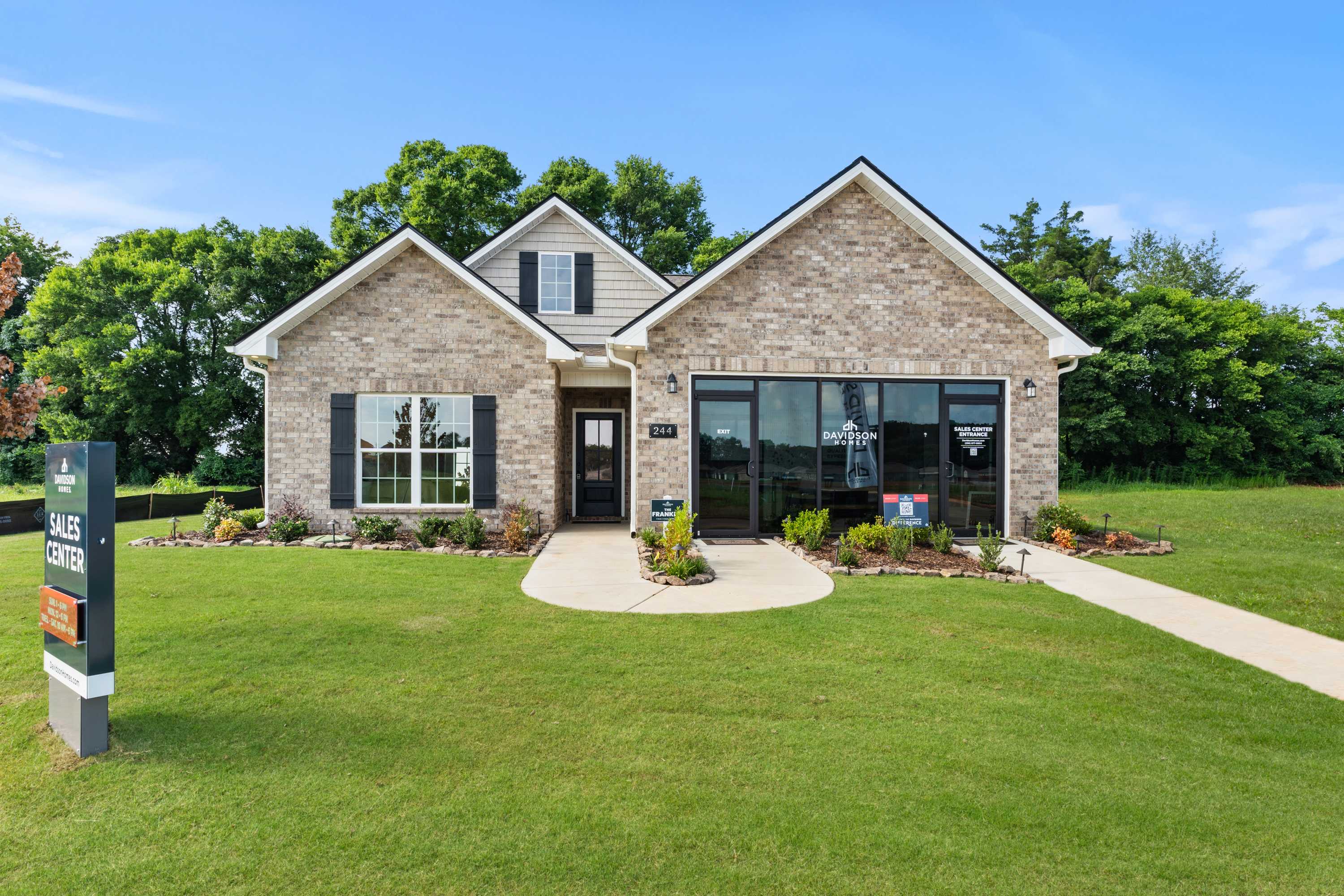Brick sales center exterior at Lynn Meadows in Meridianville, Alabama with gabled roof, large windows and landscaped lawn