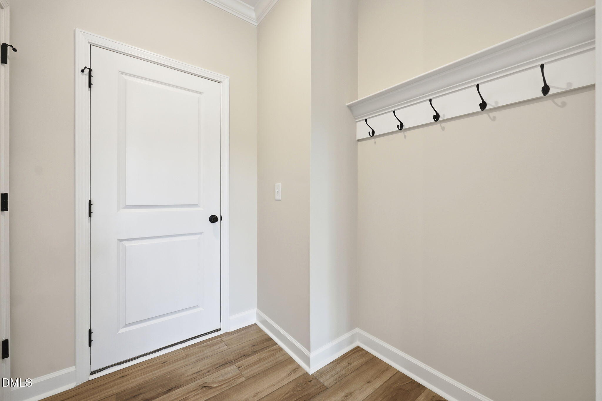 Mudroom area with wall-mounted coat hooks and wood-look flooring in The Mitchell floor plan at Camden Park, Knightdale, NC.