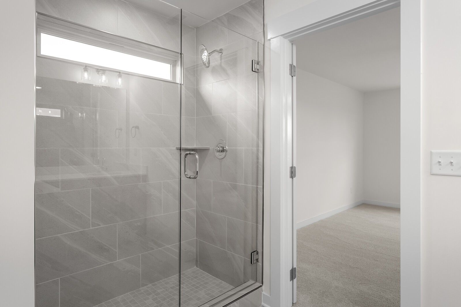 Modern frameless glass walk-in shower with gray subway tiles and rainfall head in master bathroom, Davidson Homes The Willow C, Gallatin TN