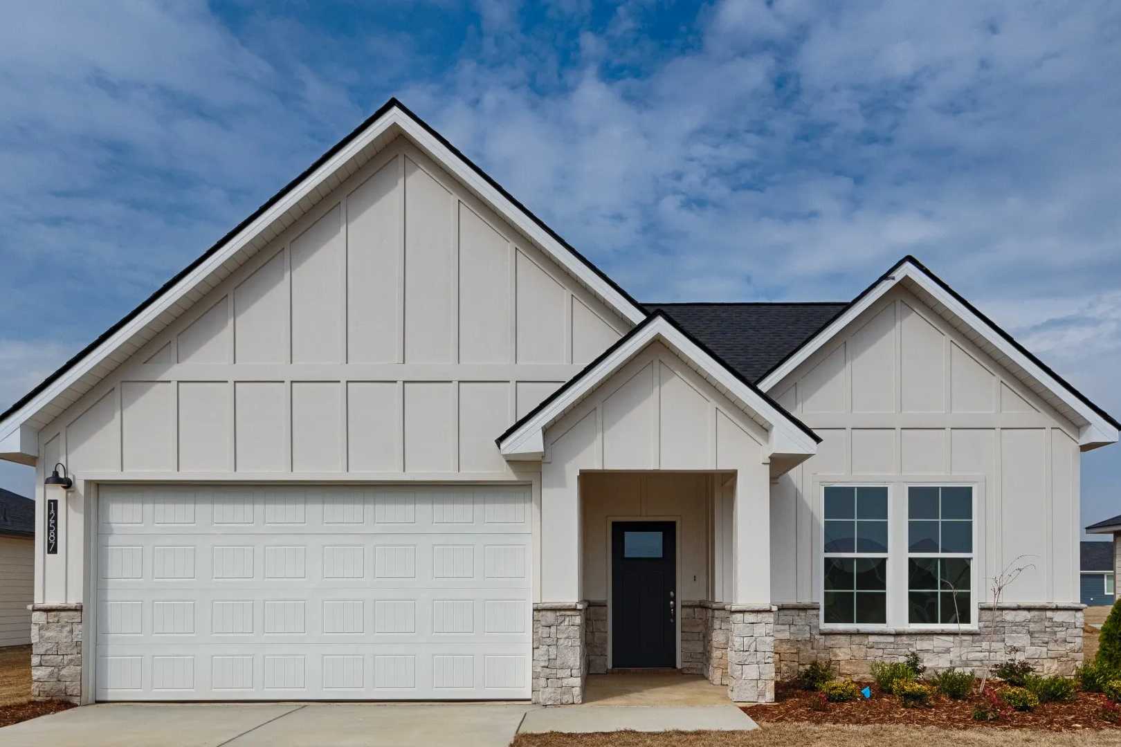 Modern farmhouse home exterior at Silver Oak in Cusseta Alabama with covered porch, stone accents and garage