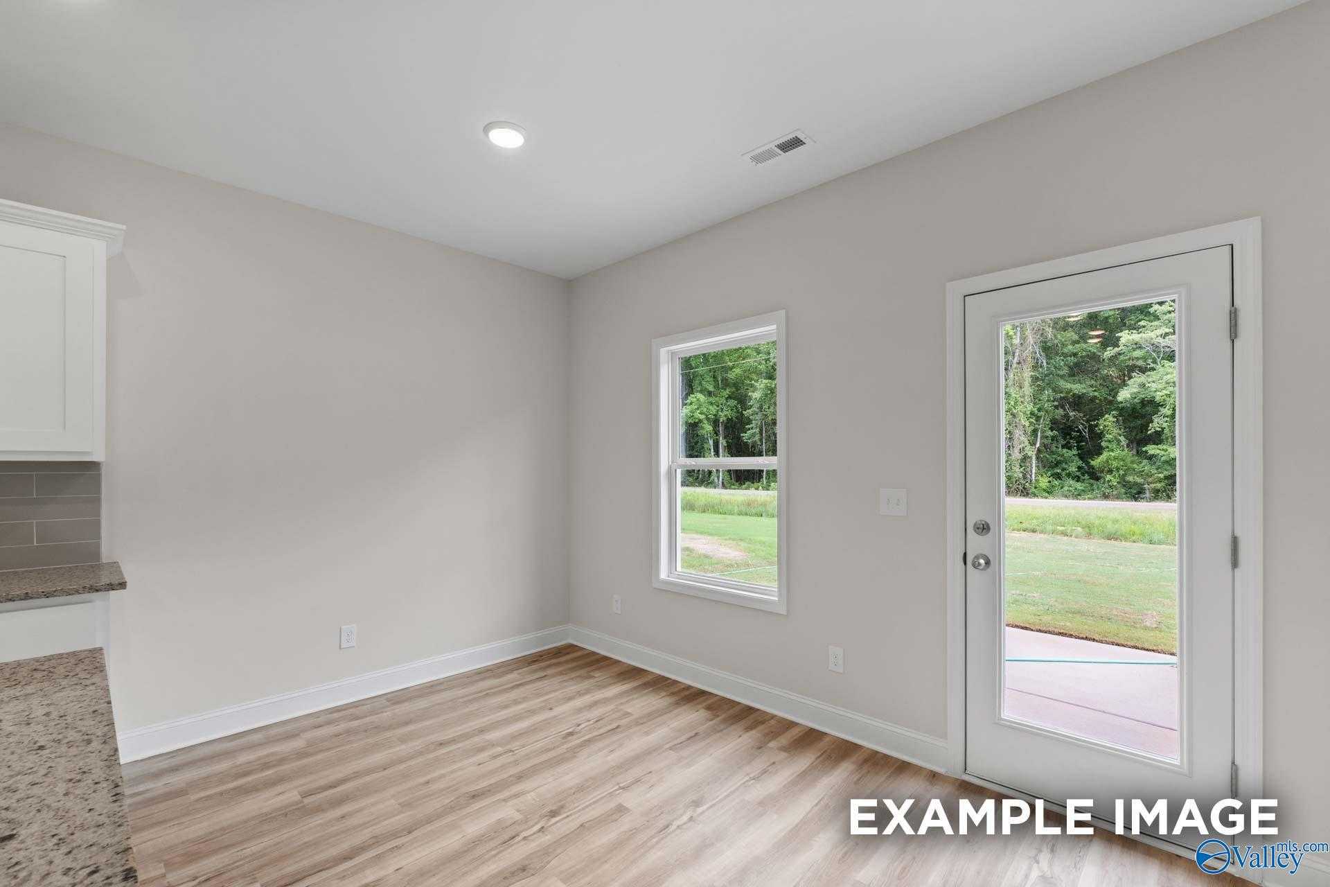 Bright flex room with white cabinets, sliding door to wooded backyard in Davidson Homes The Butler, Toney AL