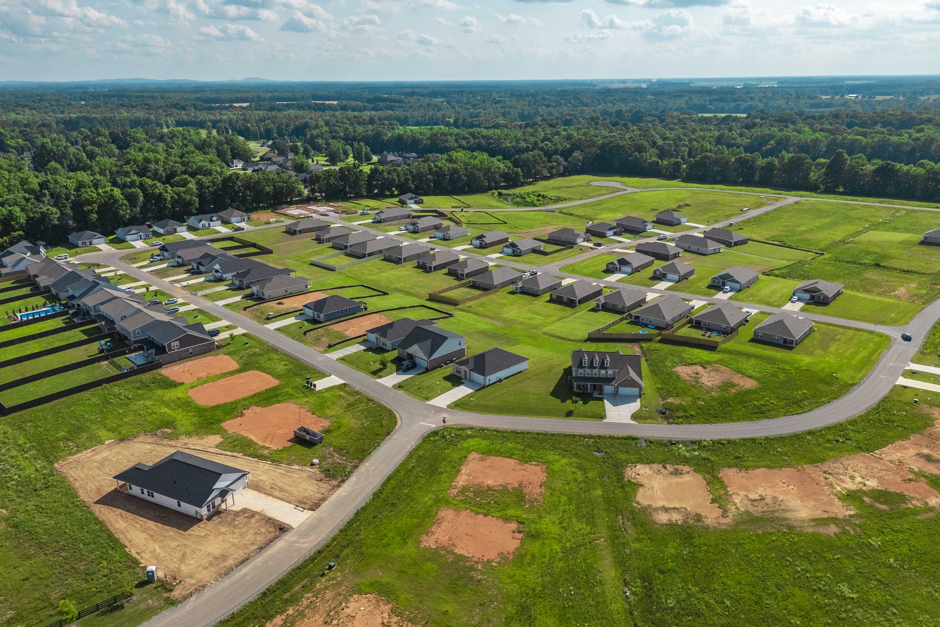 Aerial view of Bailey Park in Fayetteville TN featuring new Davidson Homes amid green lawns, construction sites and wooded surroundings