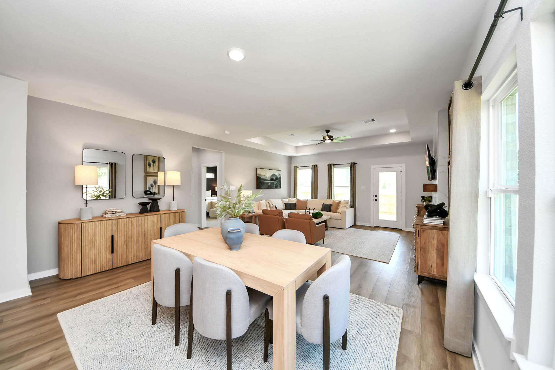 Open-concept living and dining area at Enclave at Newport in Crosby, TX by Davidson Homes with modern neutral decor.