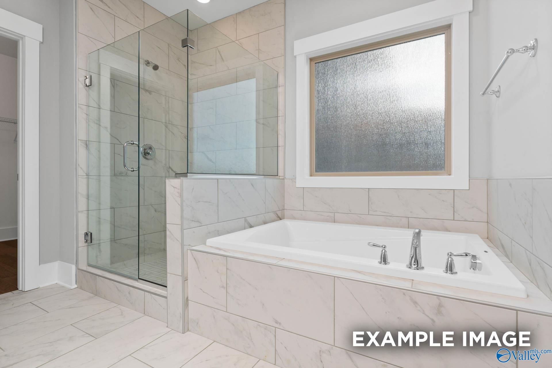 Luxurious master bathroom with frameless glass shower and soaking tub in Davidson Homes The Rockford, Meridianville, AL