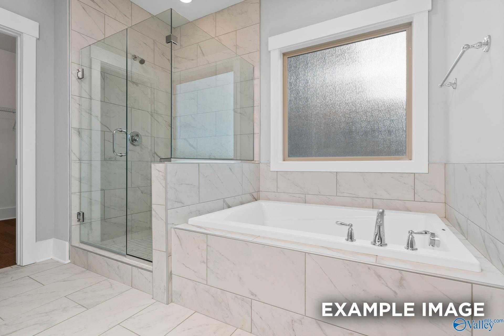 Luxurious master bathroom with frameless glass shower and soaking tub in Davidson Homes The Rockford, Meridianville, AL